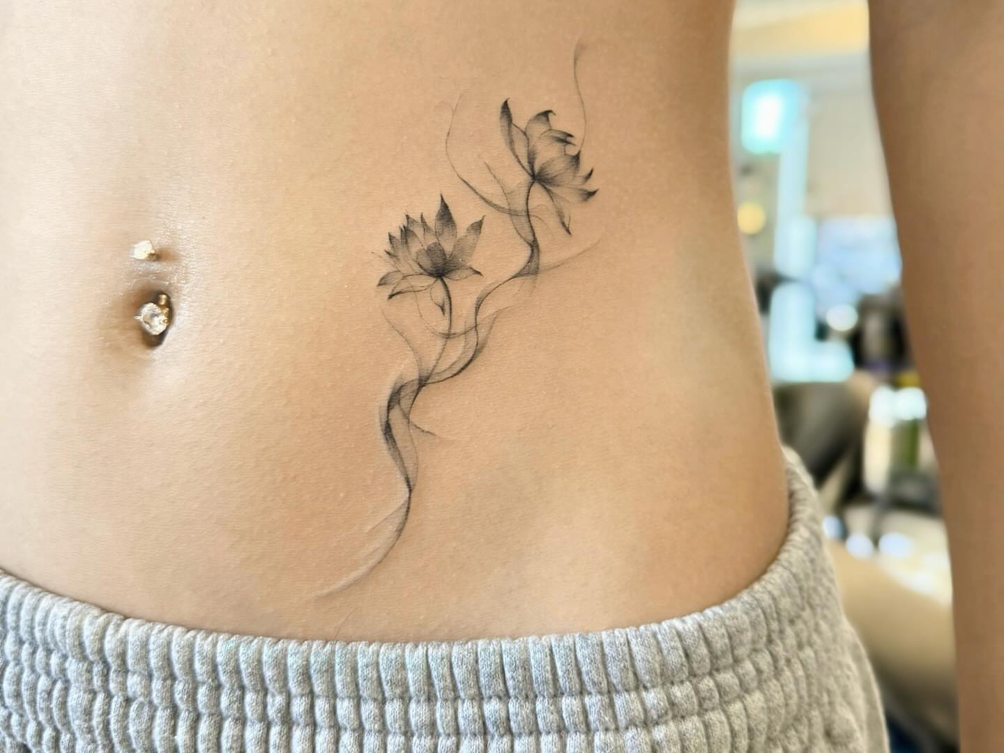 Lotus flowers black and grey tattoo on the torso by David H.