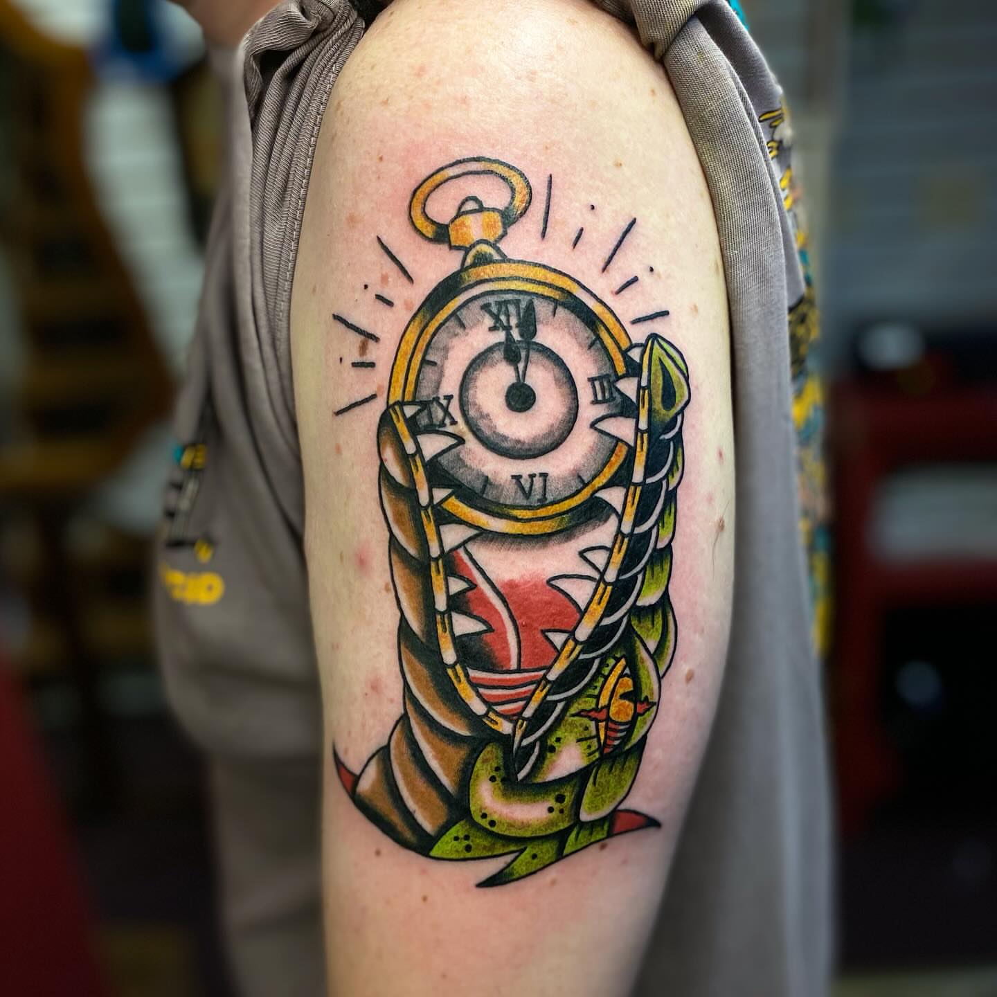 Pocket watch American traditional tattoo on the upper arm by Tommy O'Connell