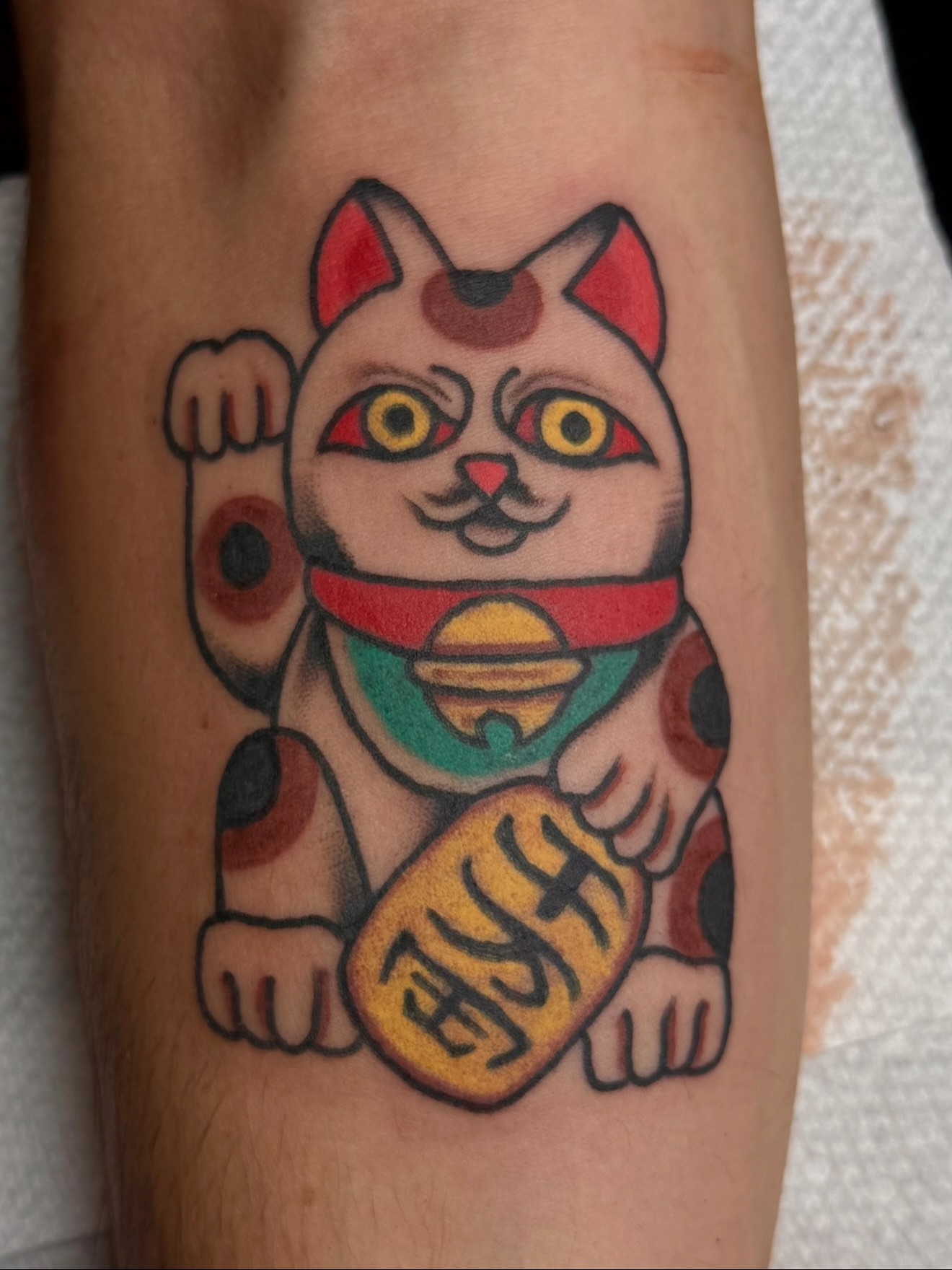 Maneki-neko American traditional tattoo on the forearm by Zac Clark