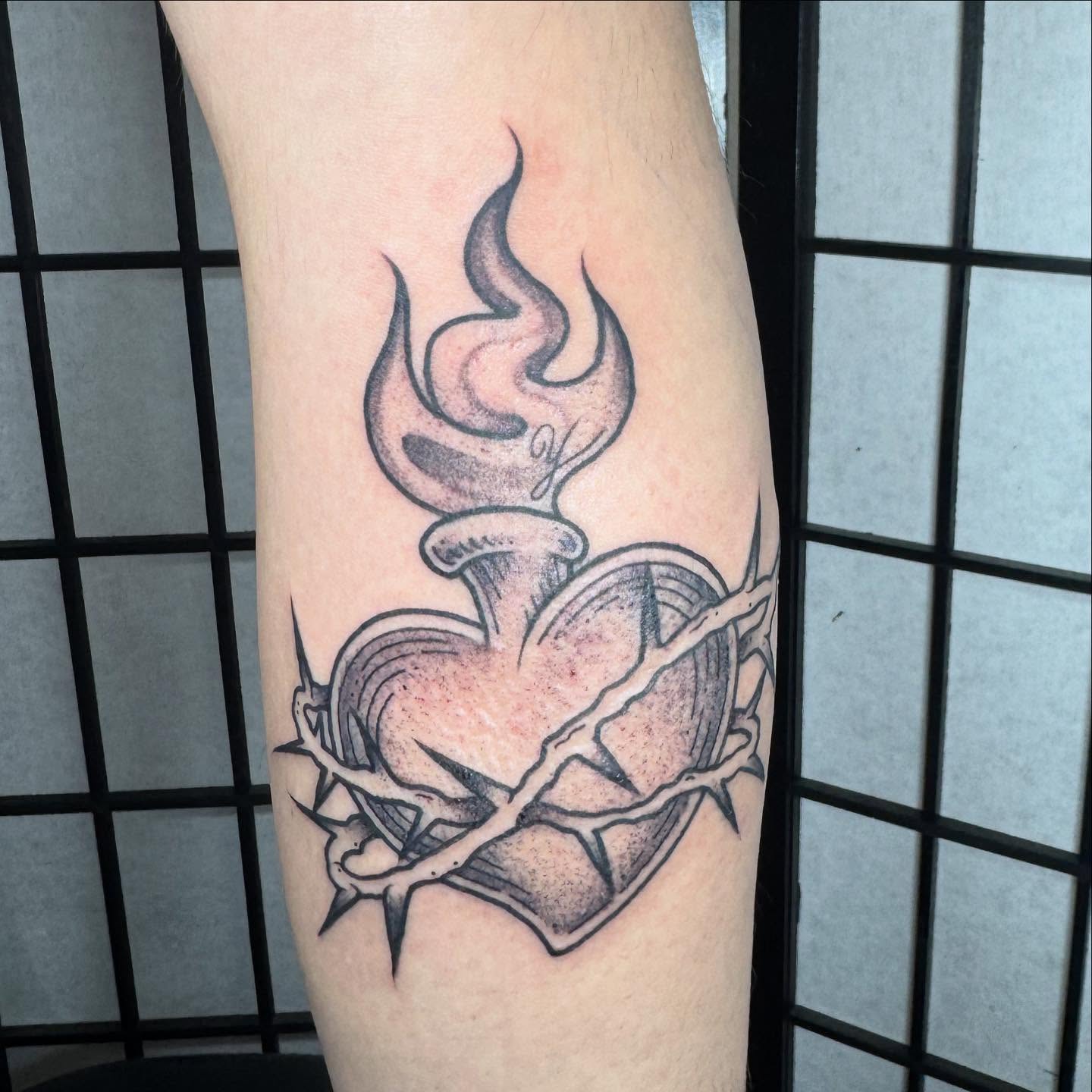 Broken heart with flame black and grey tattoo on the forearm by Justina🪐