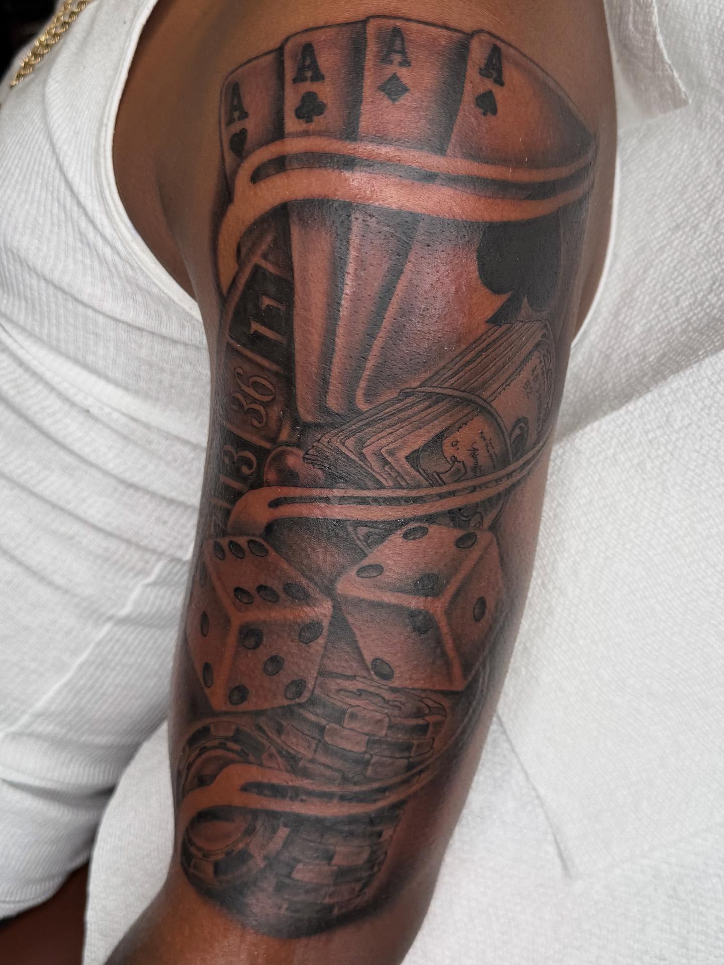 Playing cards and dice black and grey tattoo on the forearm by Las Vegas Tattoo Artist