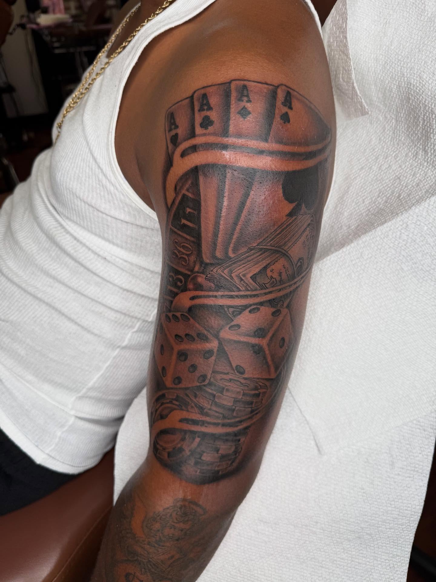 Playing cards and dice black and grey tattoo on the forearm by Las Vegas Tattoo Artist