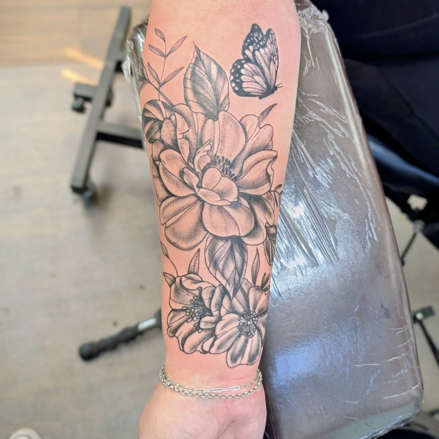 Flowers and butterfly black and grey tattoo on the forearm by Devon Ward, Portland, Oregon