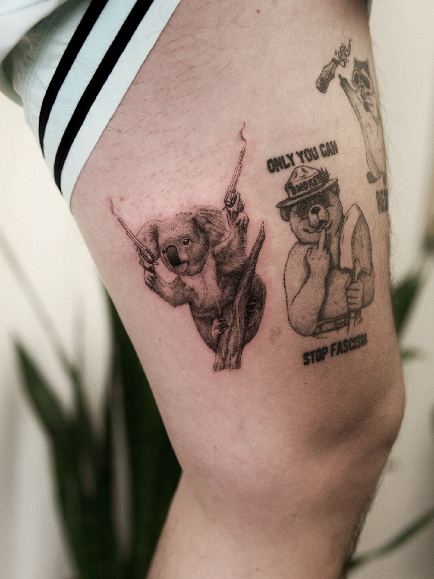 Koala and bear black and grey tattoo on the thigh by Ray Quinday
