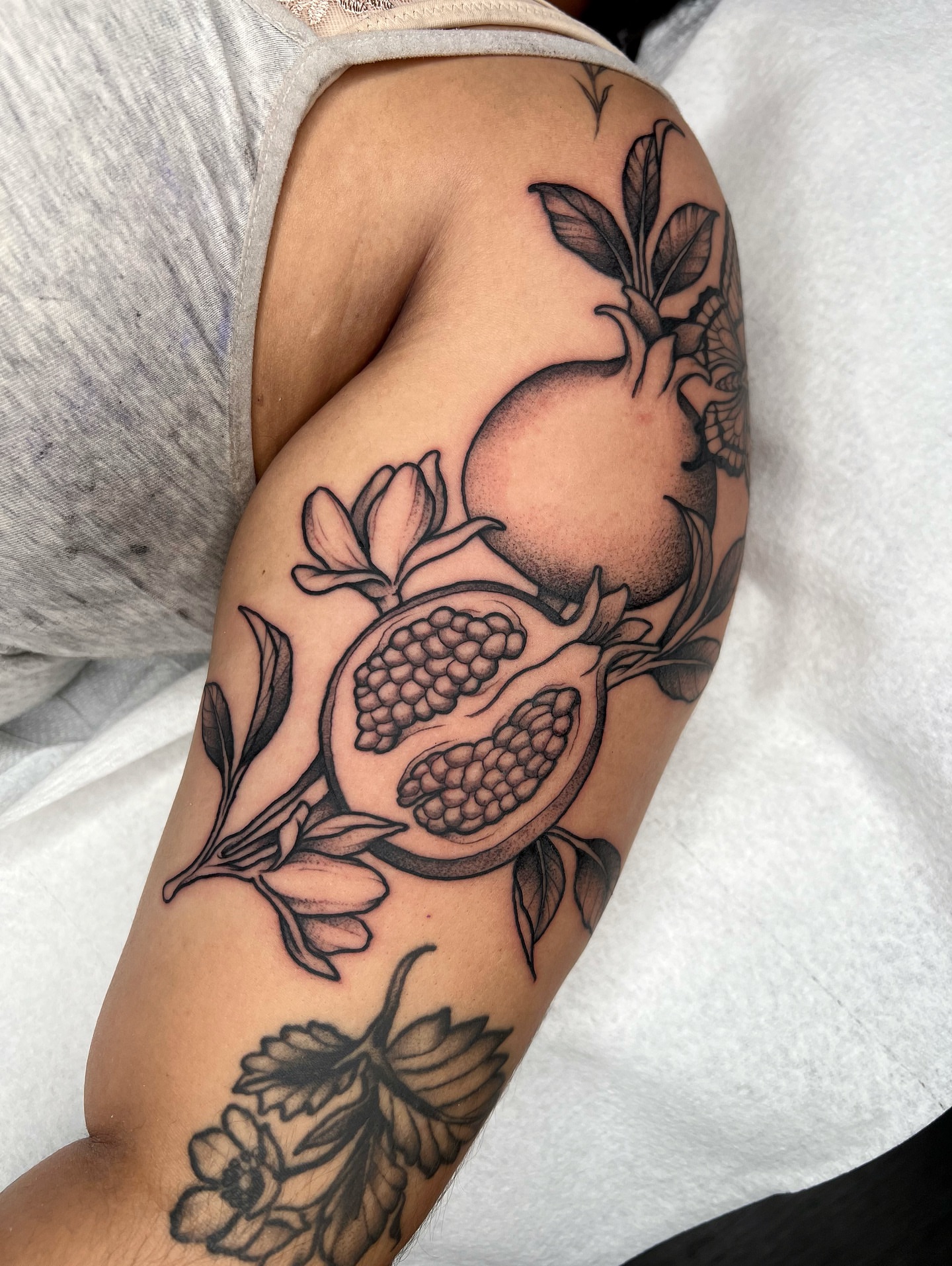 Pomegranate black and grey tattoo on the upper arm by 𝔐𝔦𝔠𝔥𝔢𝔩𝔩𝔢 ℭ𝔥𝔞𝔪𝔢𝔯𝔩𝔦𝔨