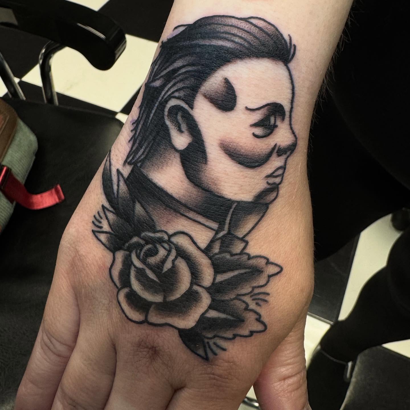 Portrait with roses black and grey tattoo on the hand by Brian Herrera