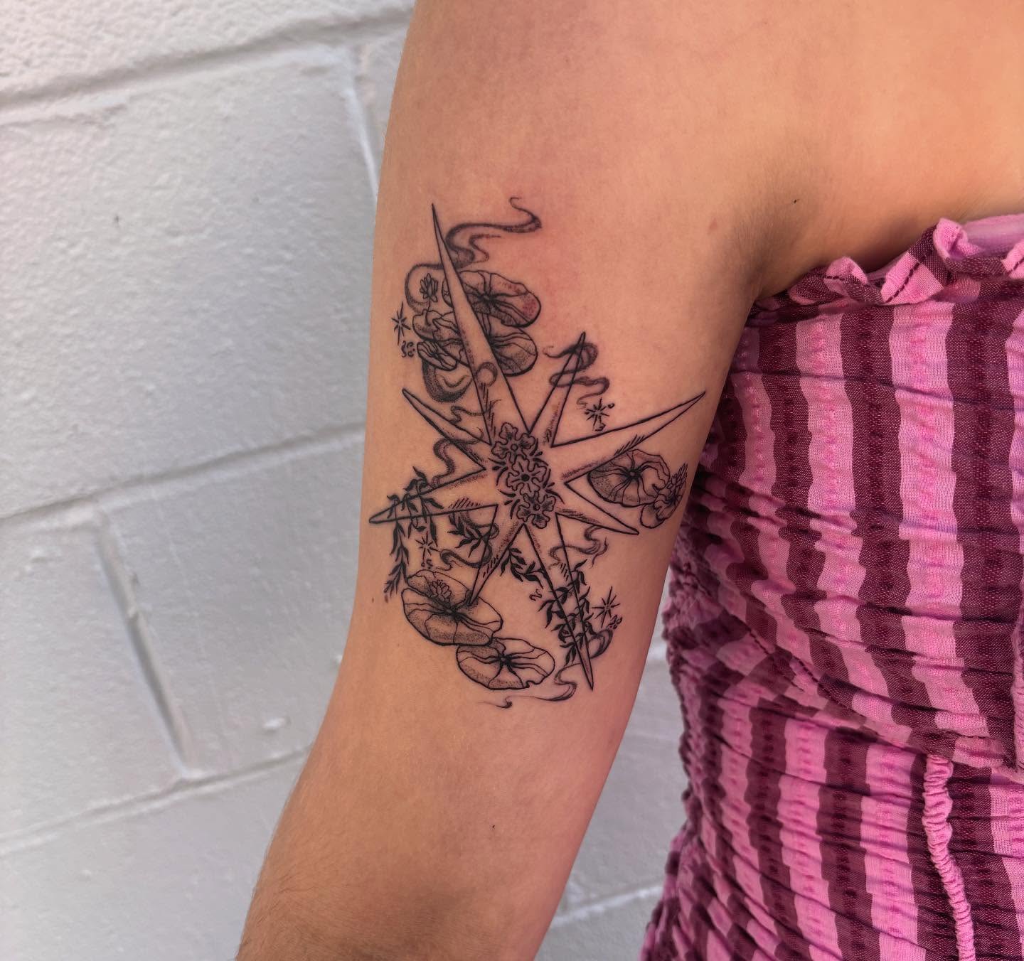 Starfish and floral black and grey tattoo on the forearm by Ashley Ellerman