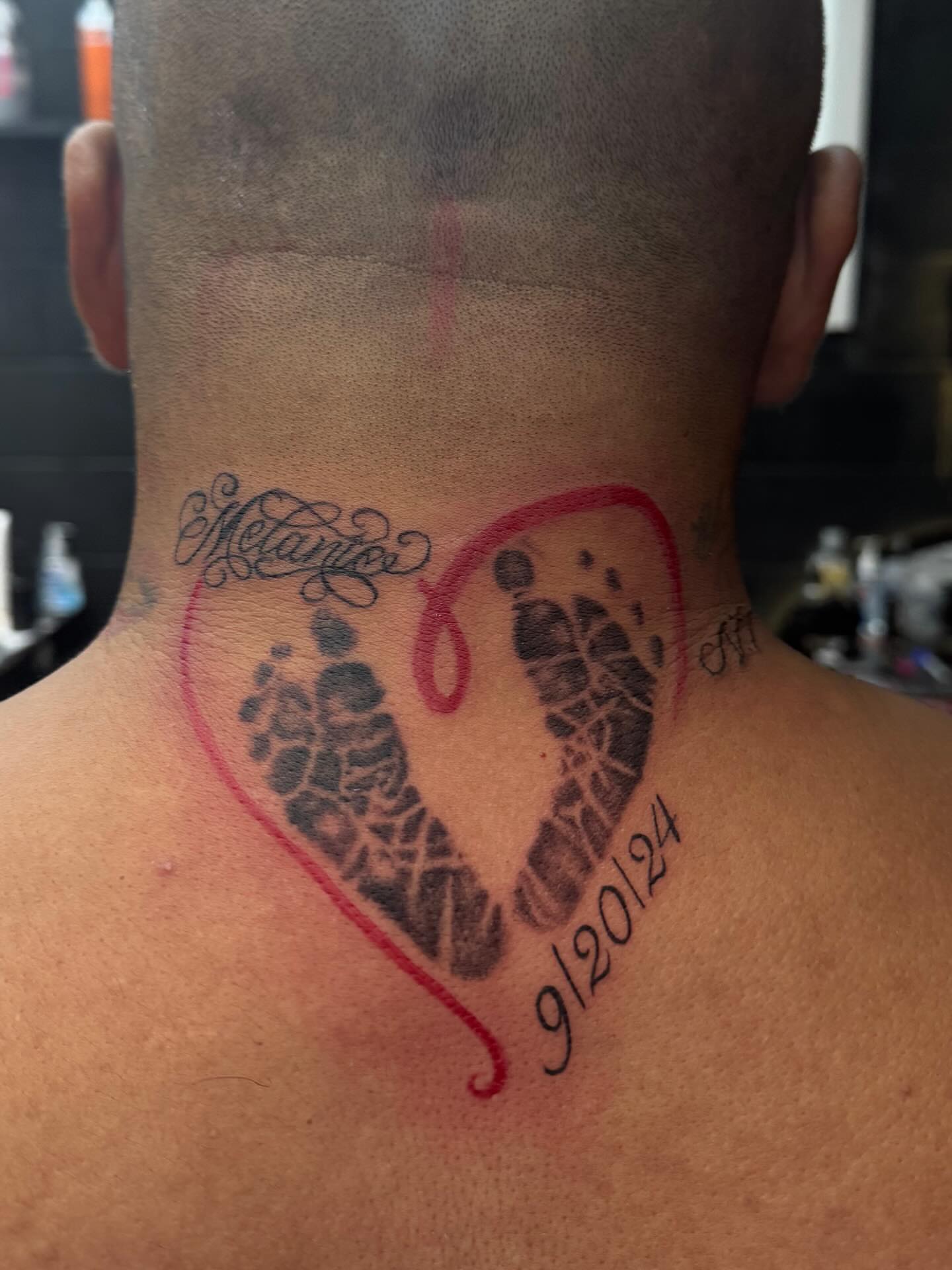 Heart with footprints dotwork tattoo on the back by @_frankyvee