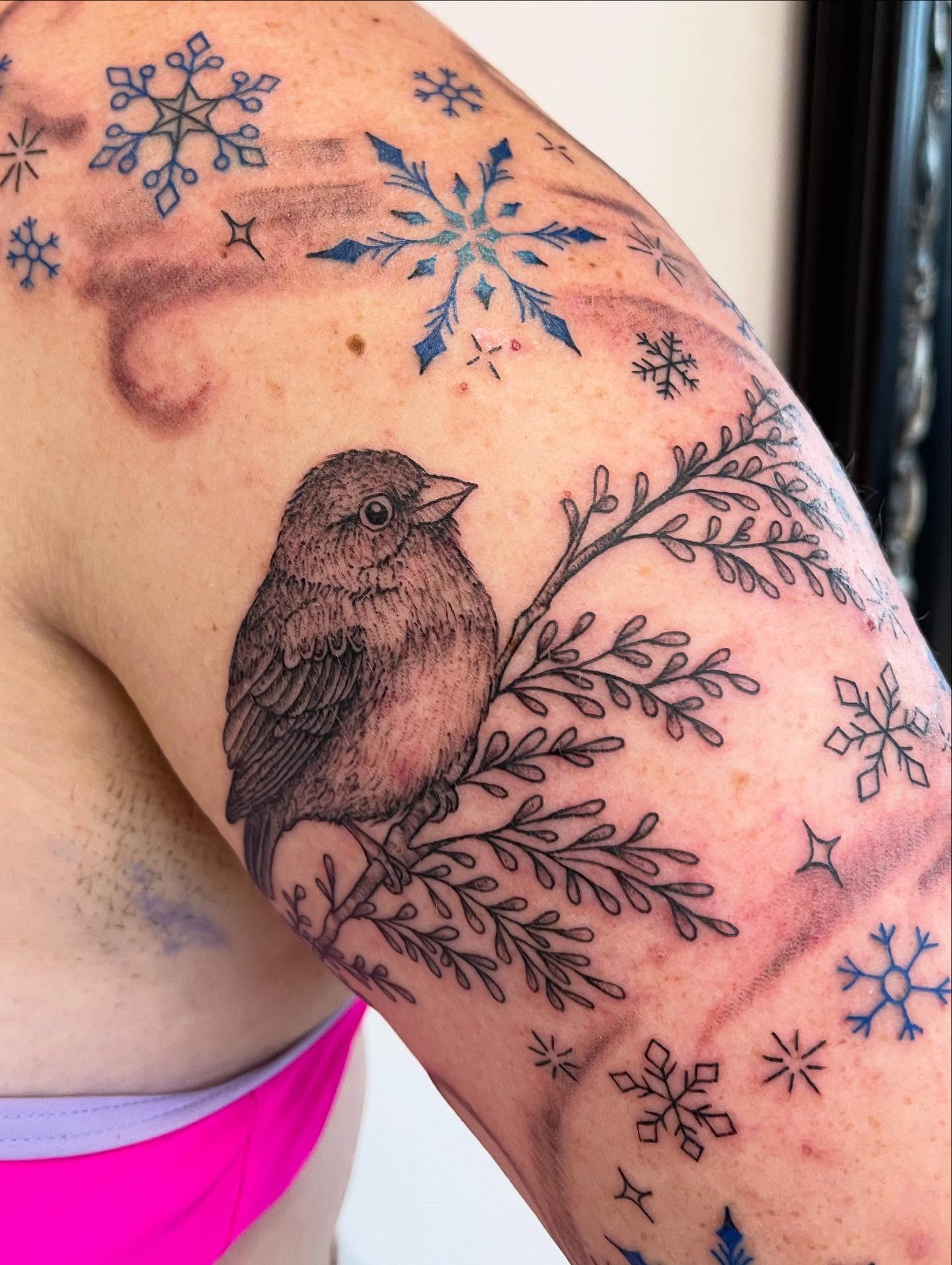 Bird and snowflakes black and grey tattoo on the forearm by Miesha Busker
