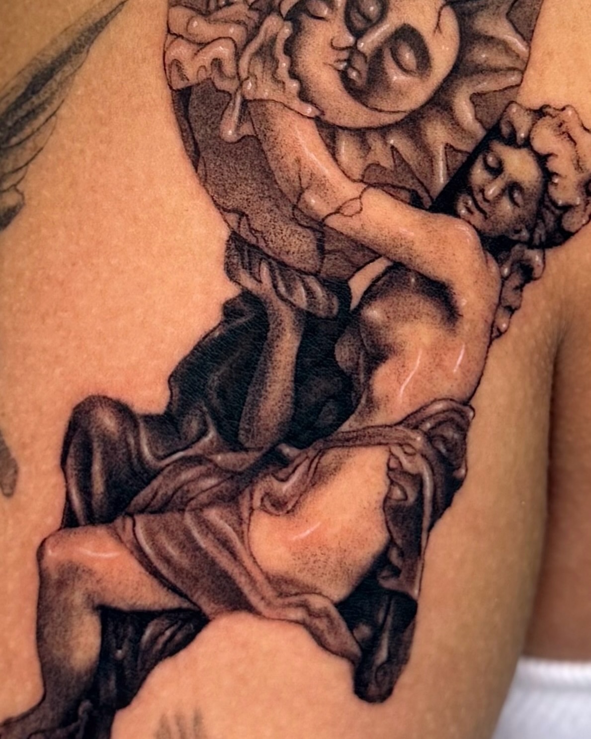 Statue of a man and woman realism tattoo on the shoulder by Mystikal Blue Casares