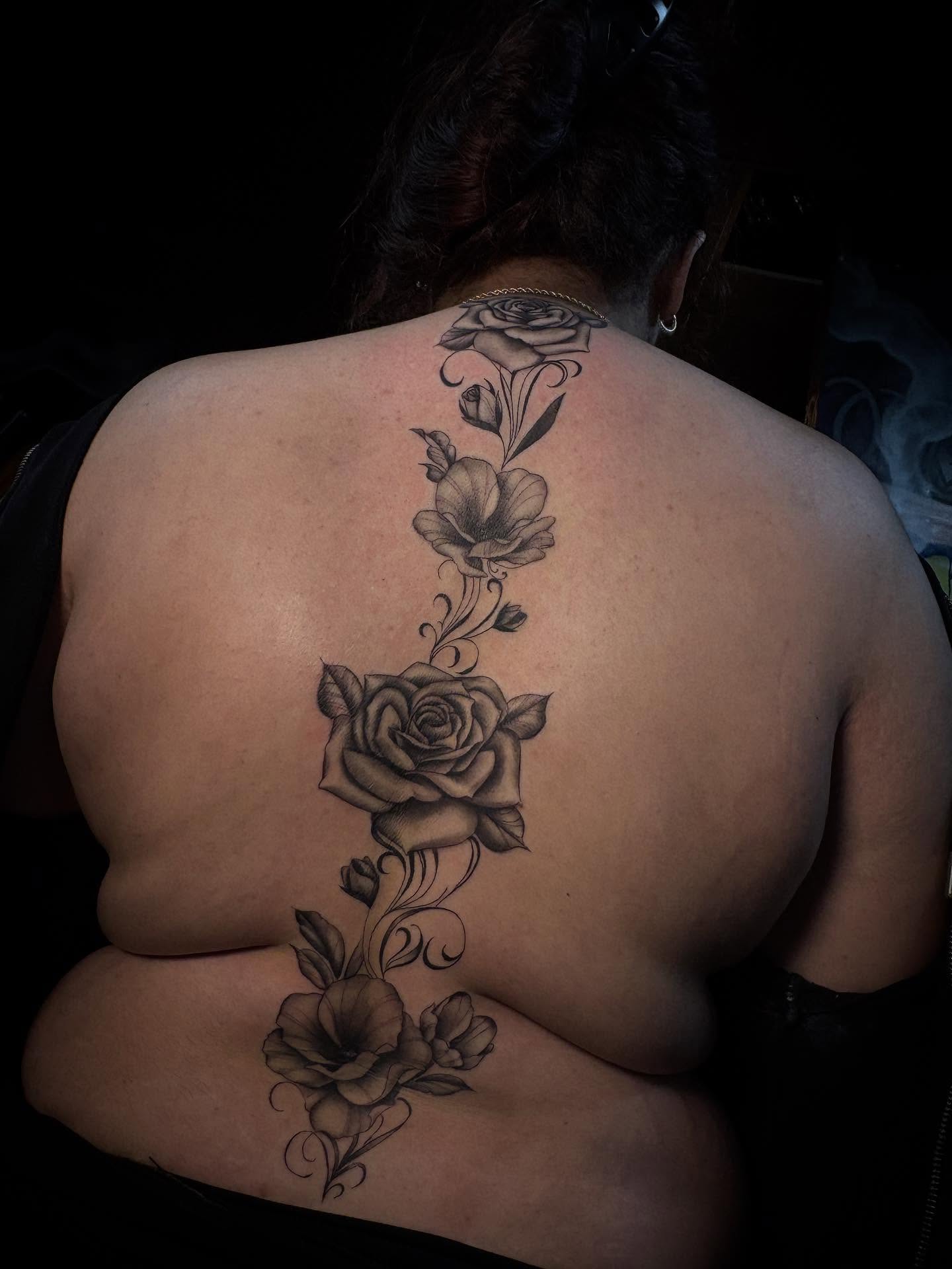 Floral arrangement black and grey tattoo on the back by Alexandria