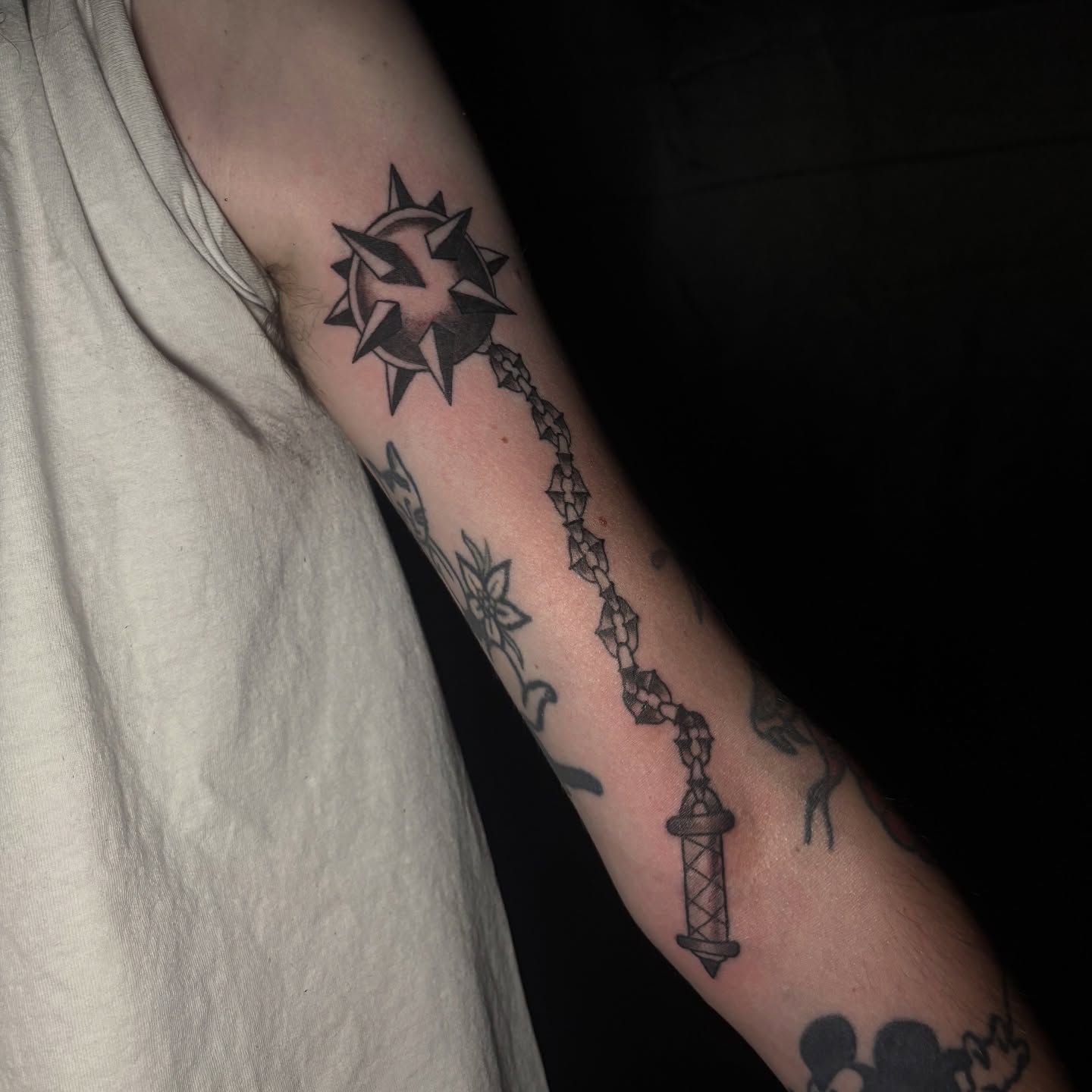 Chain and star black and grey tattoo on the forearm by Rachel