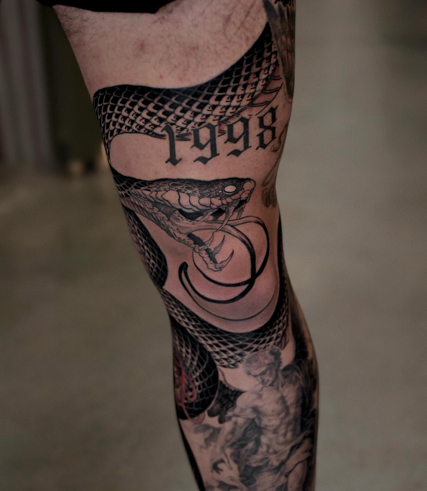 Snake and year black and grey tattoo on the forearm by Gary Zhong, Upland, California