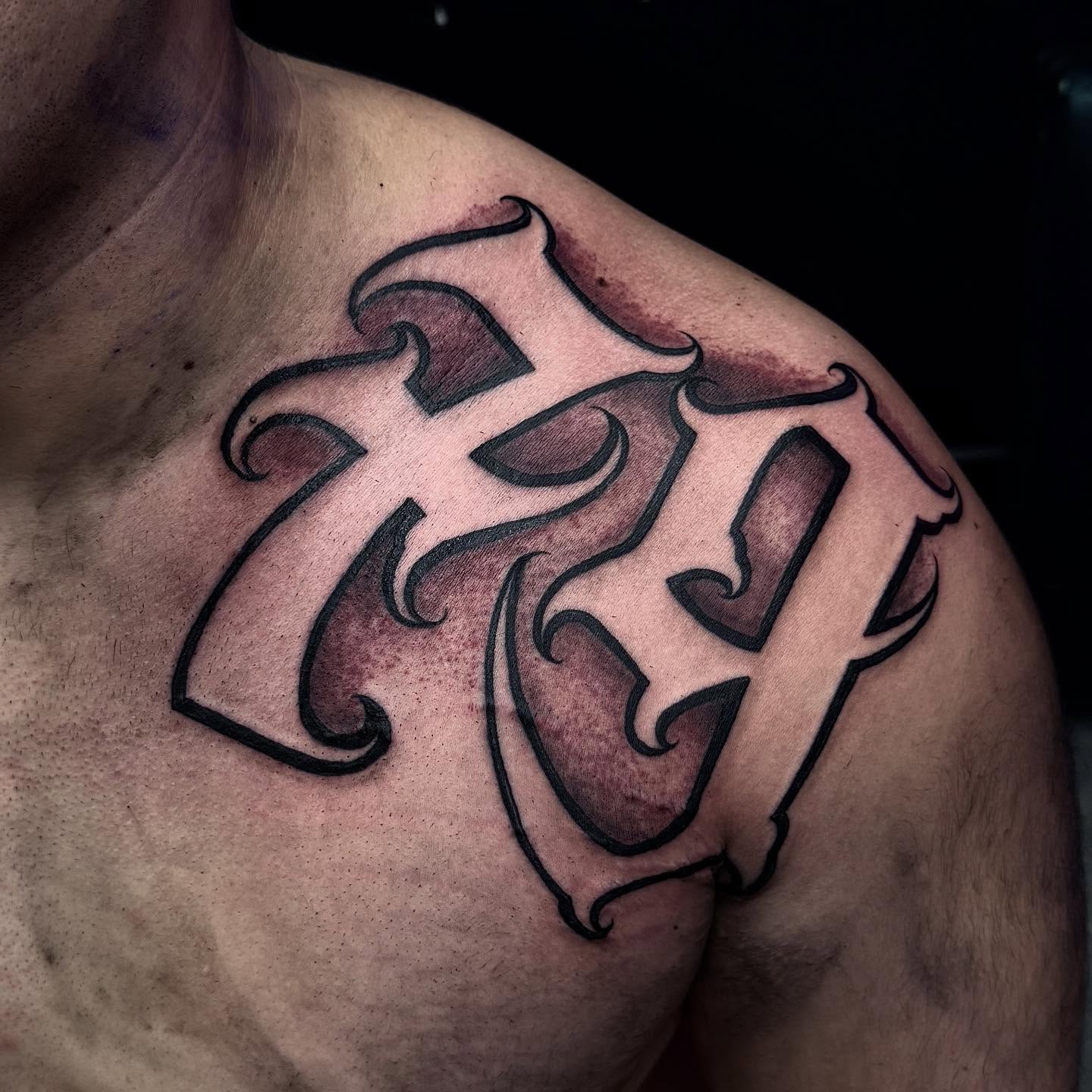 Cross black and grey tattoo on the shoulder by Joey Moreno