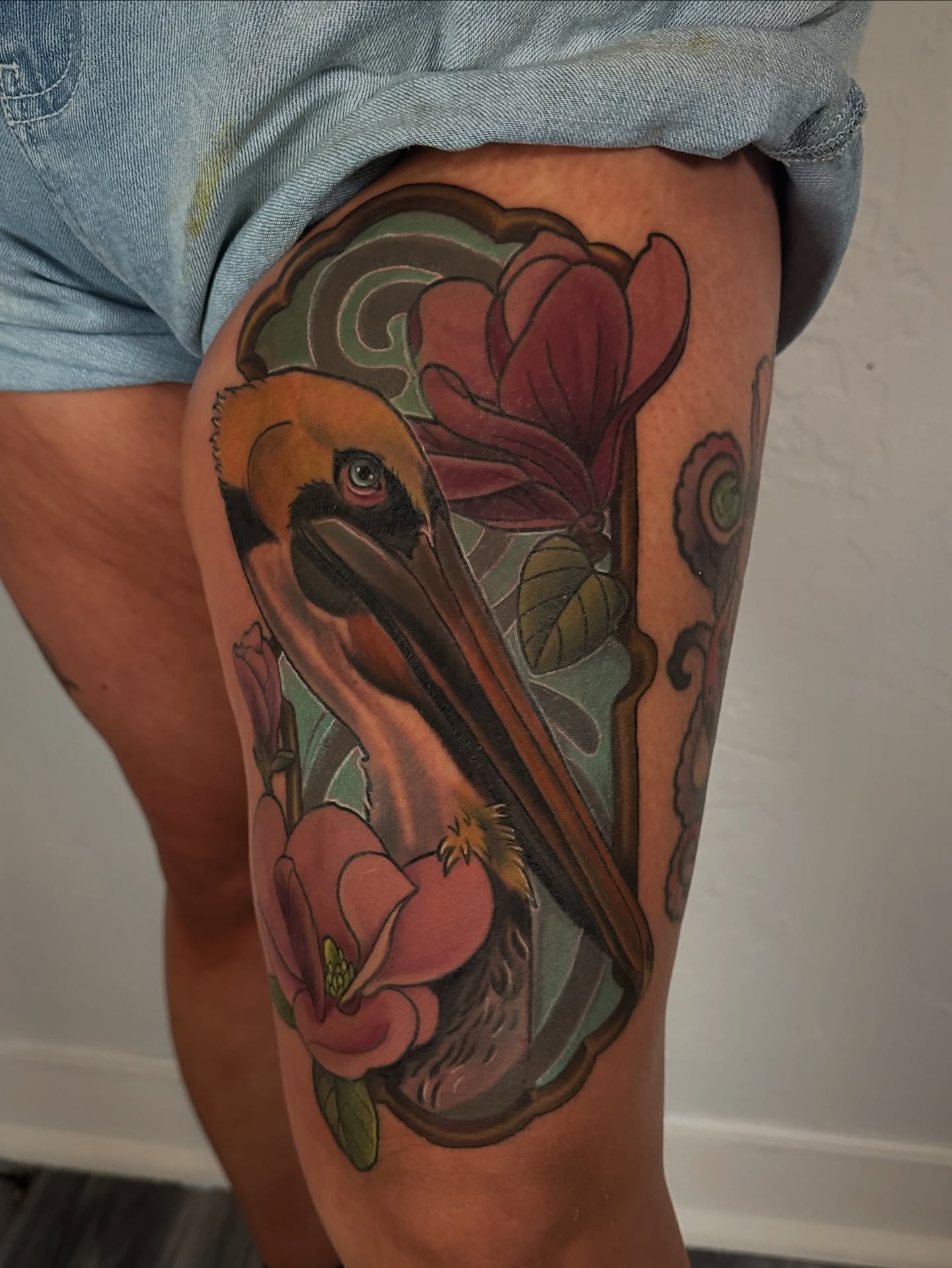 Pelican and magnolia realism tattoo on the thigh by ✨Sarah Knapp✨, Eugene, Oregon