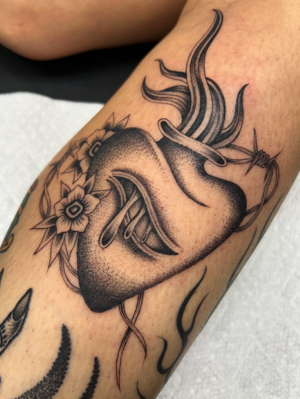 Heart with barbed wire dotwork tattoo on the forearm by Tiffany Vargas