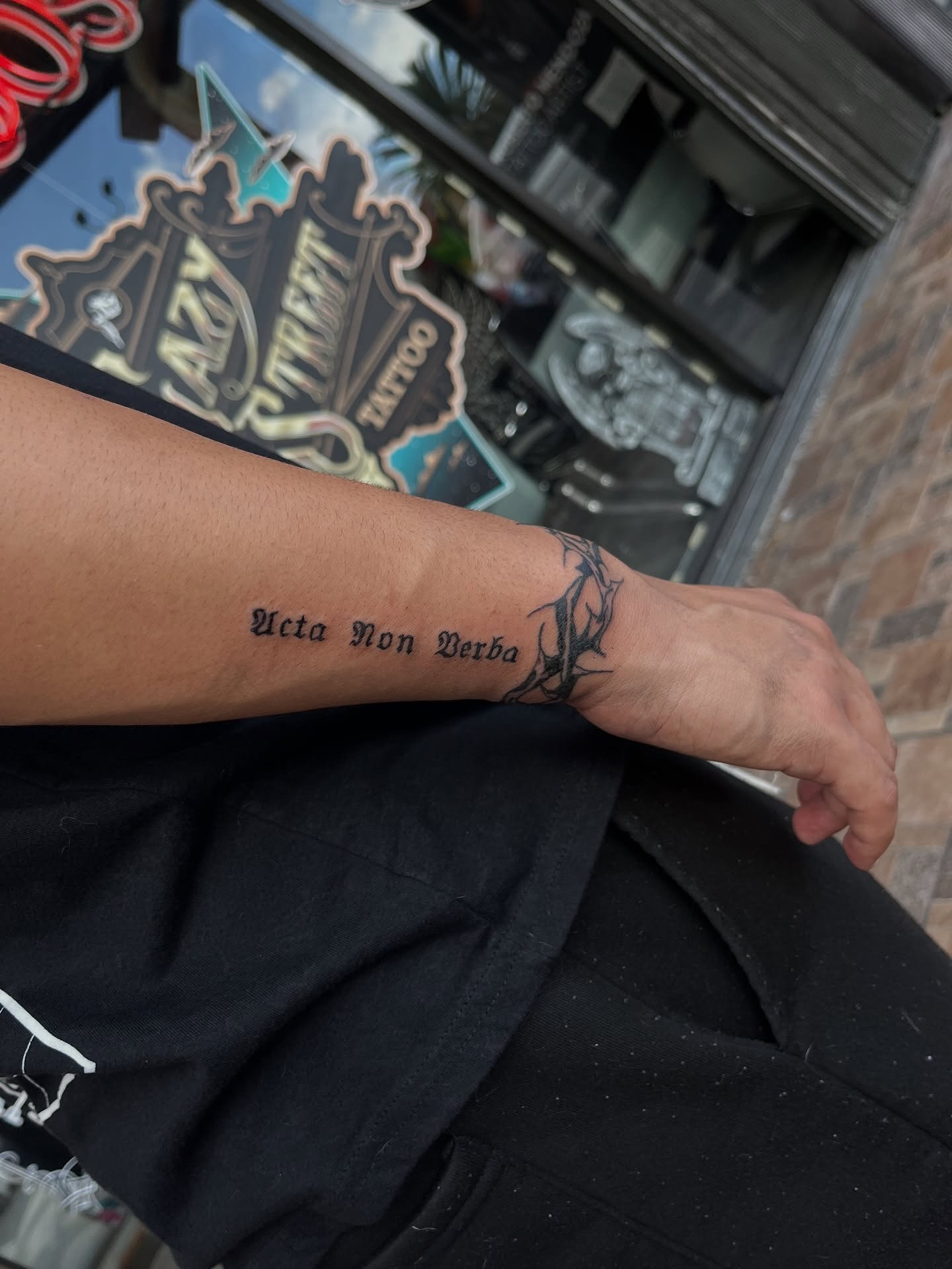 Latin phrase black and grey tattoo on the forearm by Elijah Cosme, Miami, Florida