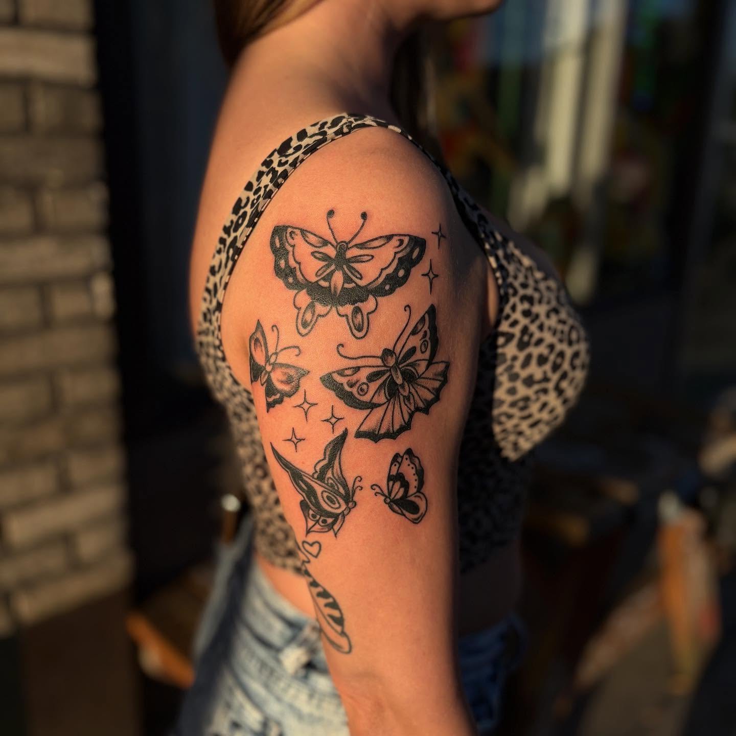 Butterflies black and grey tattoo on the upper arm by Lauren Deets