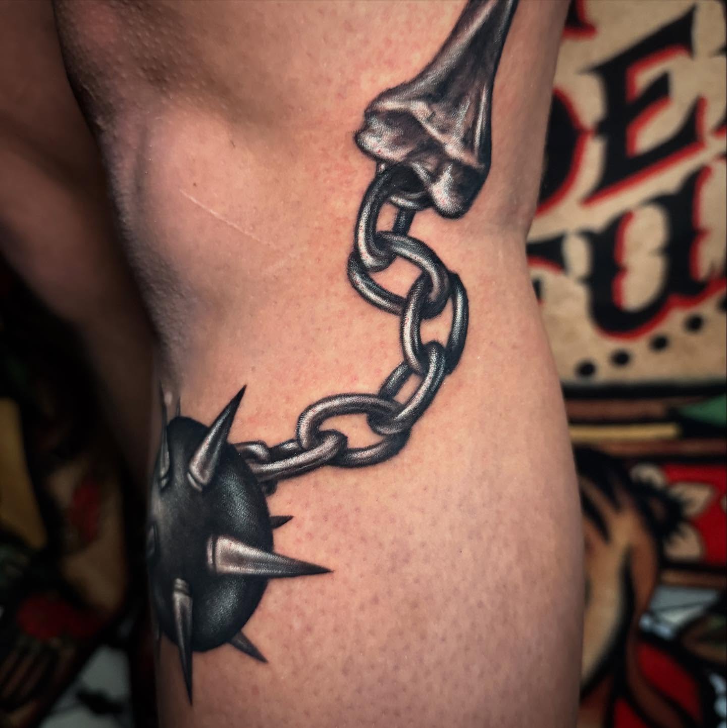 Chain and spike realism tattoo on the thigh by Alexis Monkiewicz