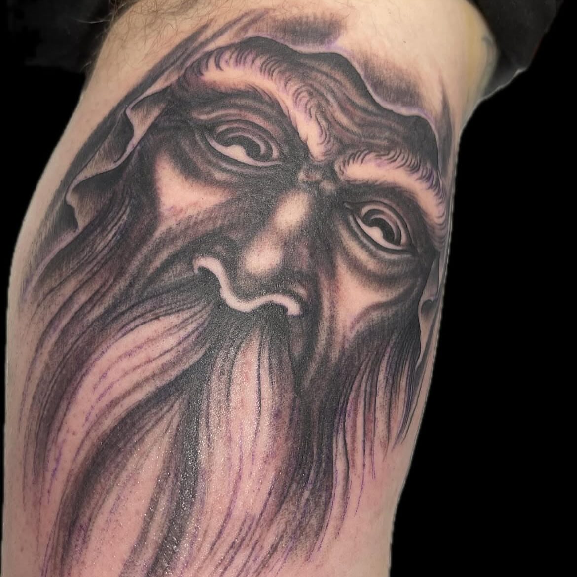 Bearded face realism tattoo on the forearm by Mike Wilson