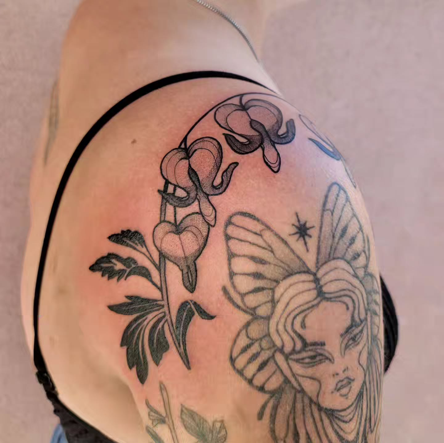Heart-shaped flowers and butterfly black and grey tattoo on the shoulder by Taylor