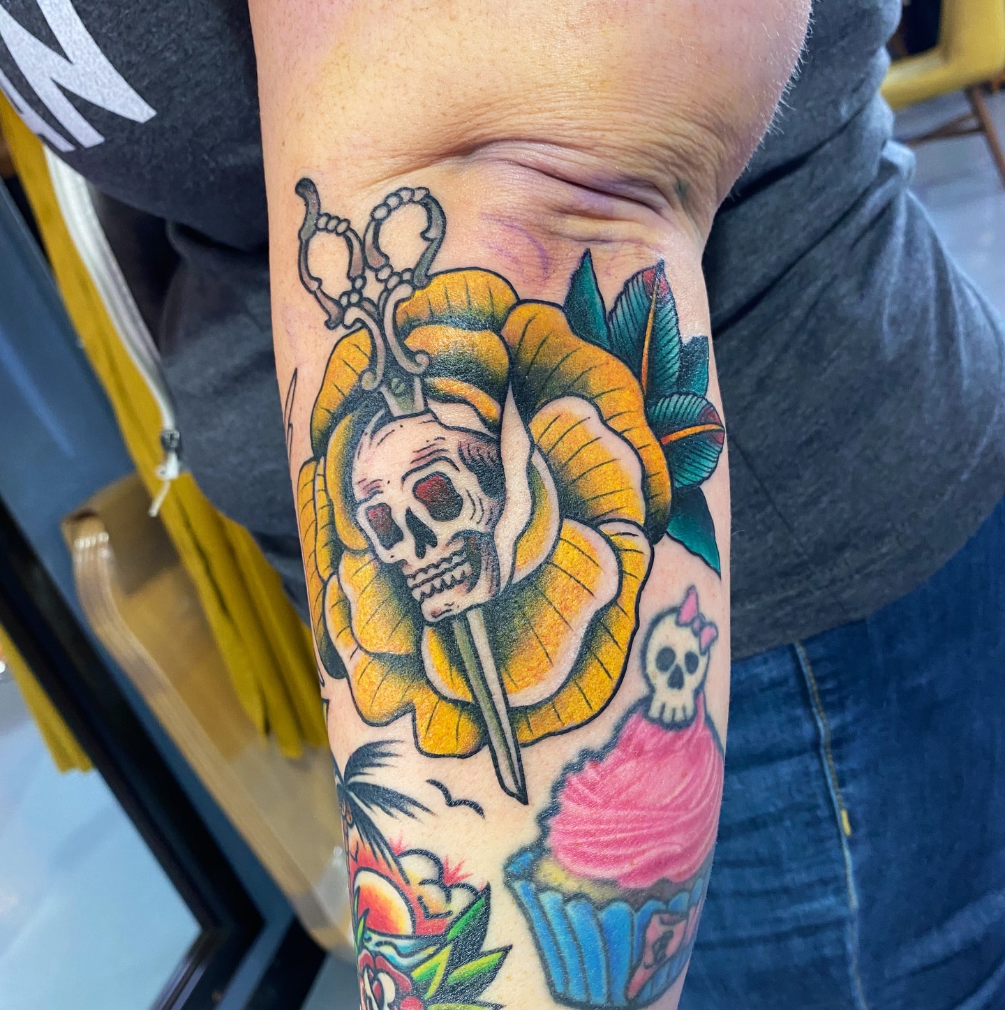 Skull and flower American traditional tattoo on the forearm by Nick Weaver