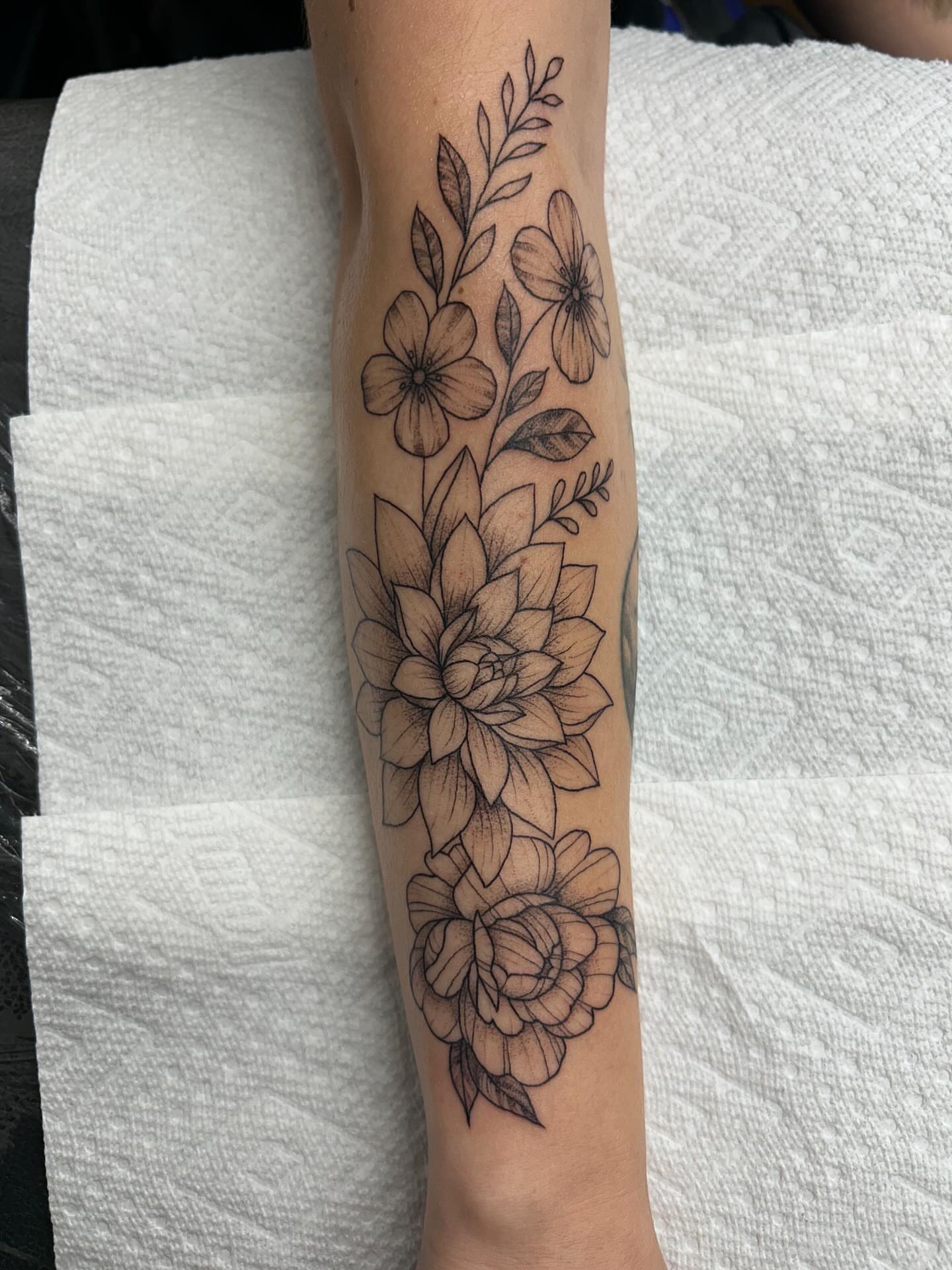 Floral arrangement black and grey tattoo on the forearm by 𝕯𝖆𝖓𝖎