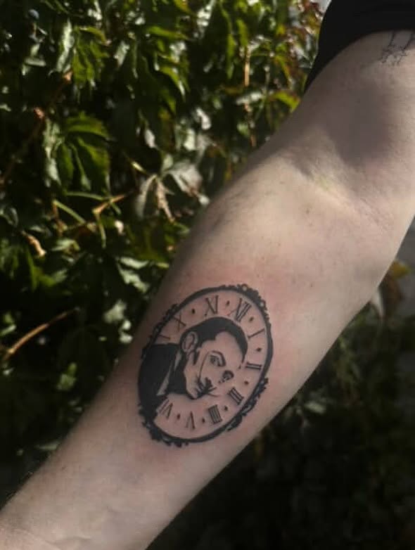 Clock with portrait black and grey tattoo on the forearm by Trinity