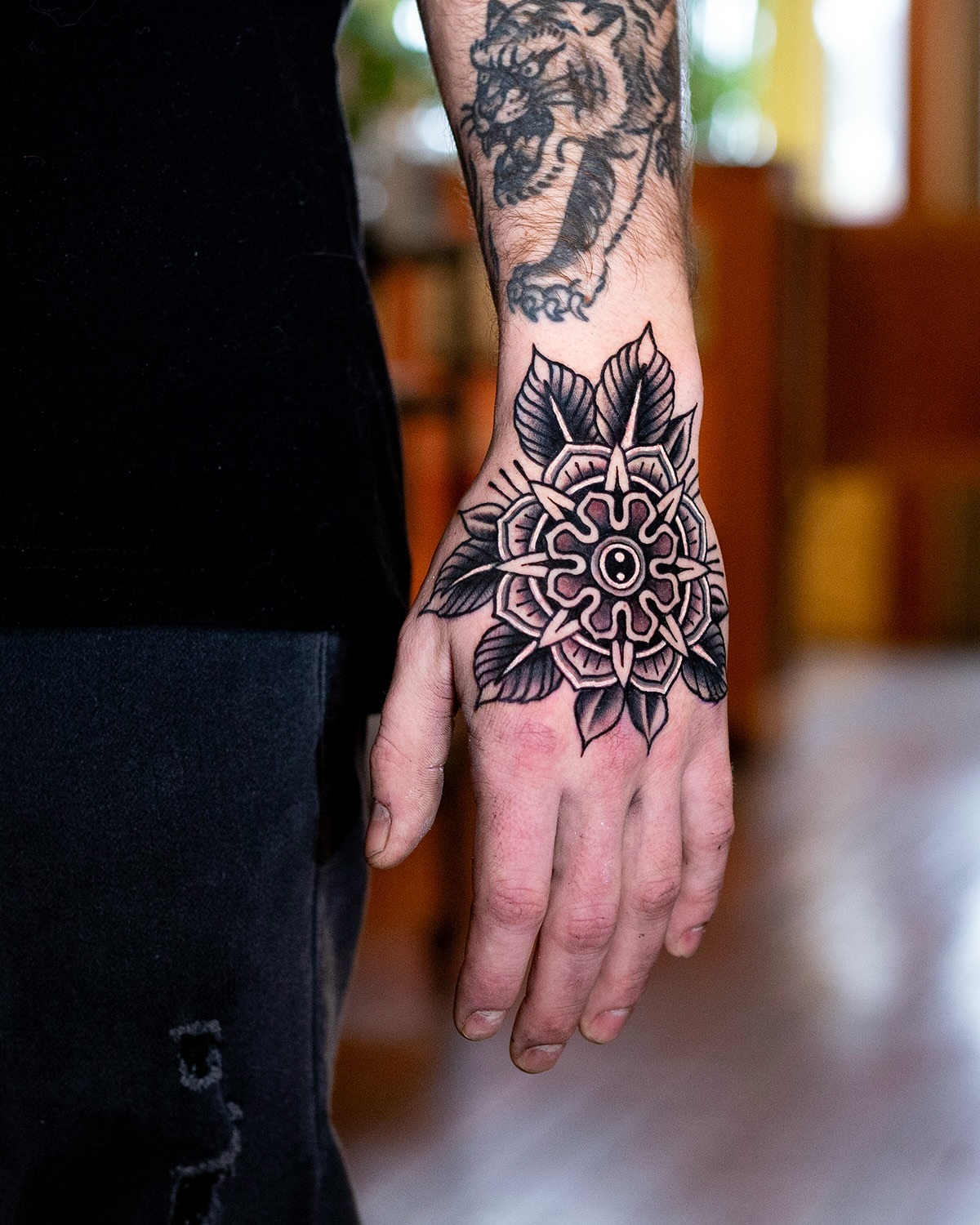 Mandala black and grey tattoo on the hand by Miguel Comin