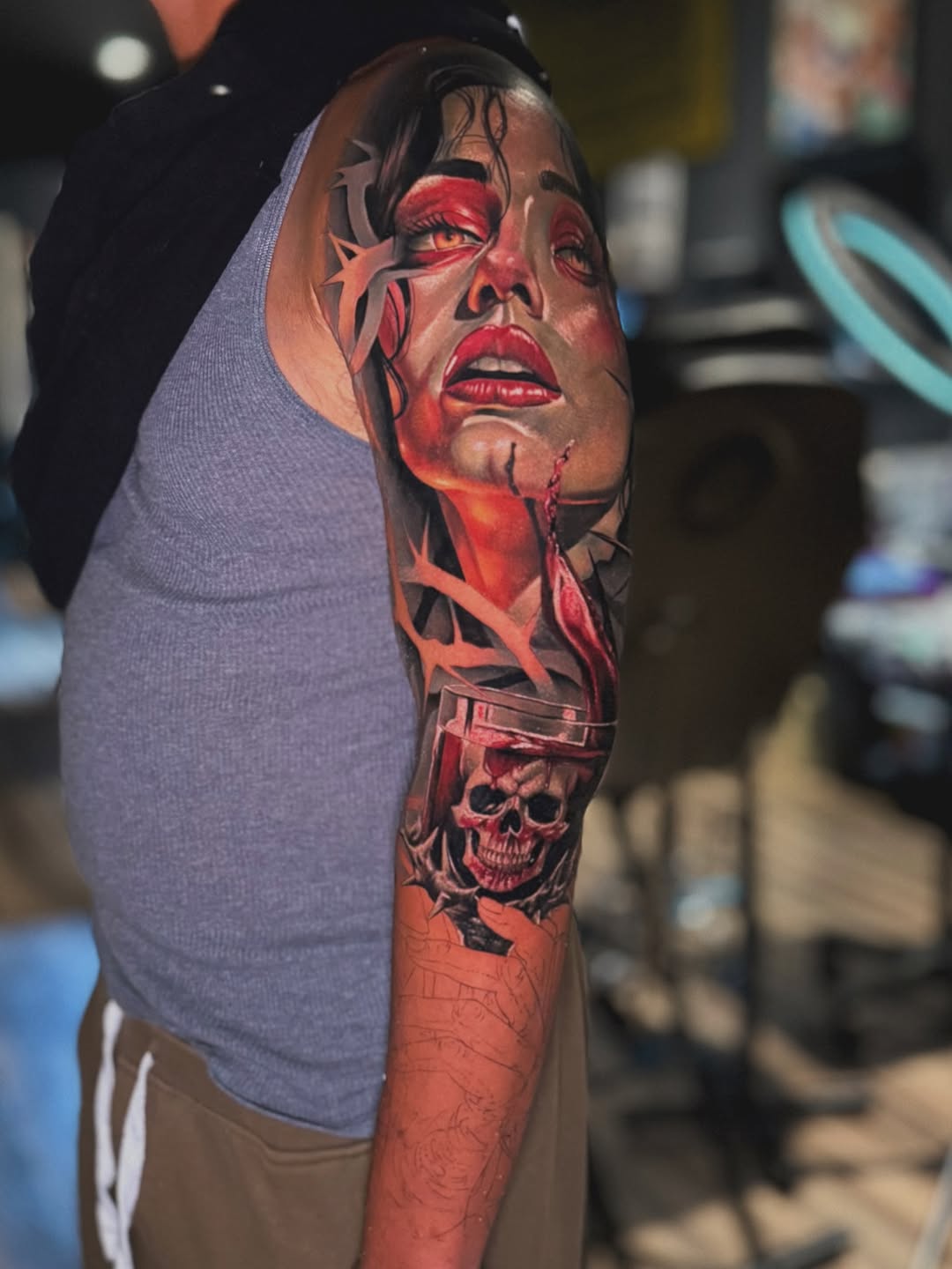 Woman's face and skull in glass surrealism tattoo on the forearm by Bailey Hancock