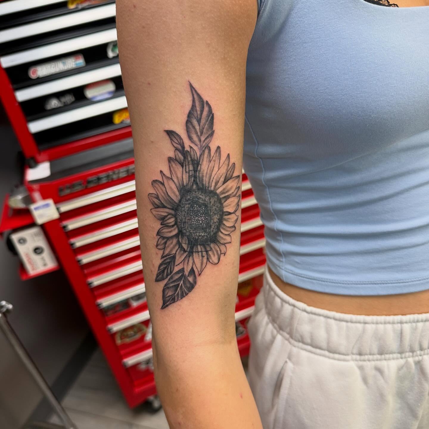 Sunflower black and grey tattoo on the forearm by Daniel Smith