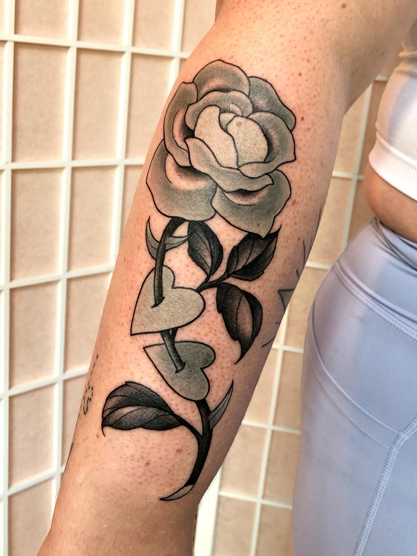 Rose black and grey tattoo on the forearm by Leah Leinani