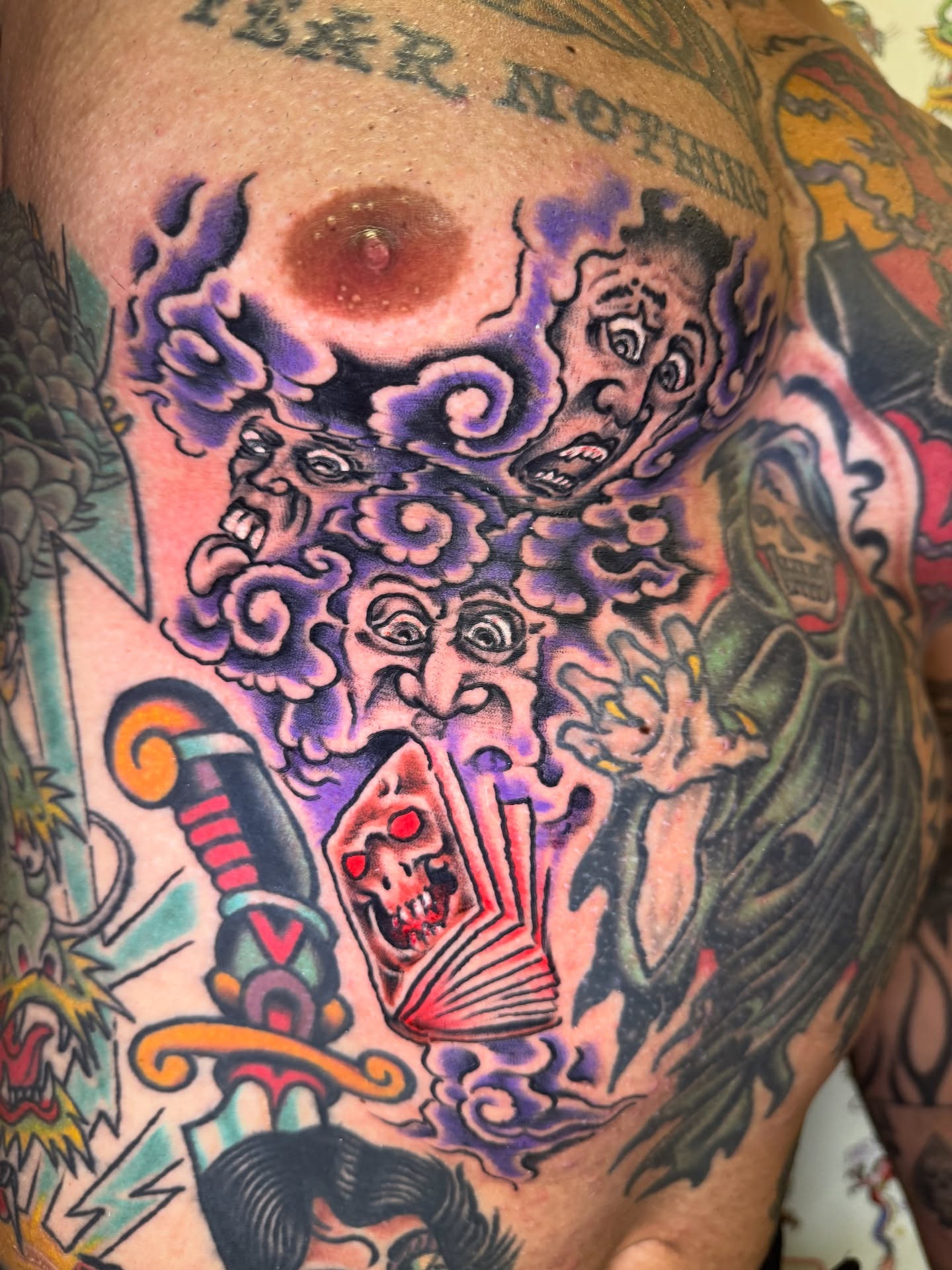 Demon faces and skull American traditional tattoo on the chest by Mike Dunn