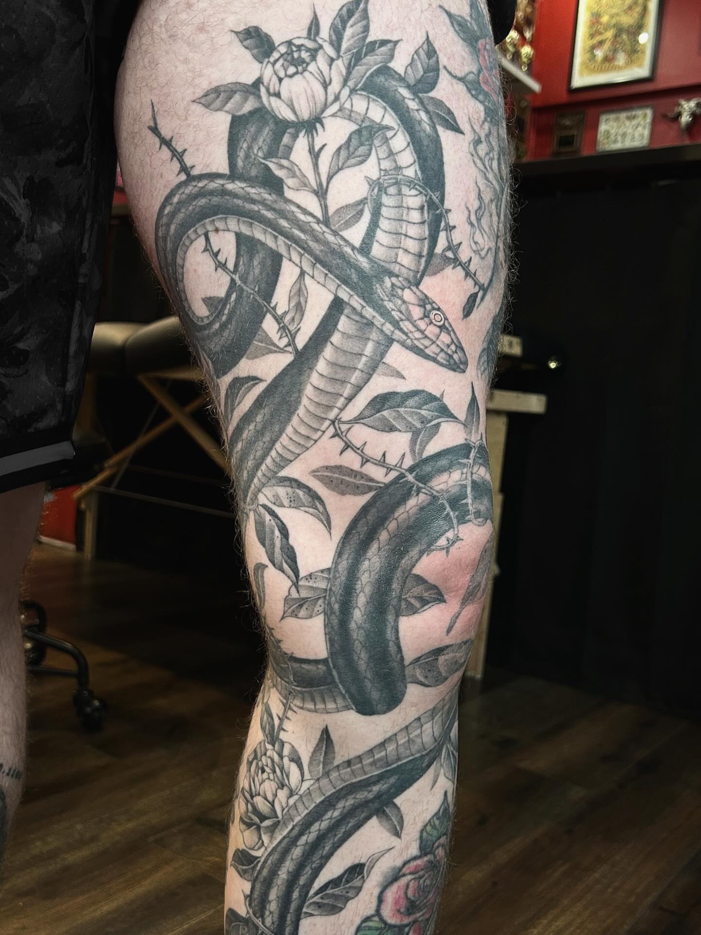 Snake and flowers realism tattoo on the leg by Tako, Seattle, Washington