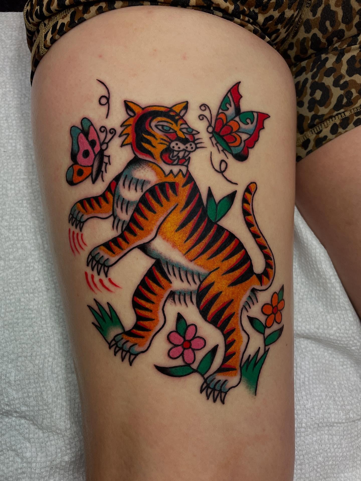 Tiger and butterflies American traditional tattoo on the thigh by Britt Kuechenmeister, Culver City, California
