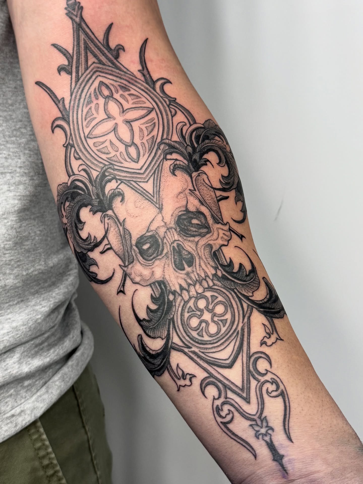 Skull and ornamental design geometric tattoo on the forearm by Erick Mendivil
