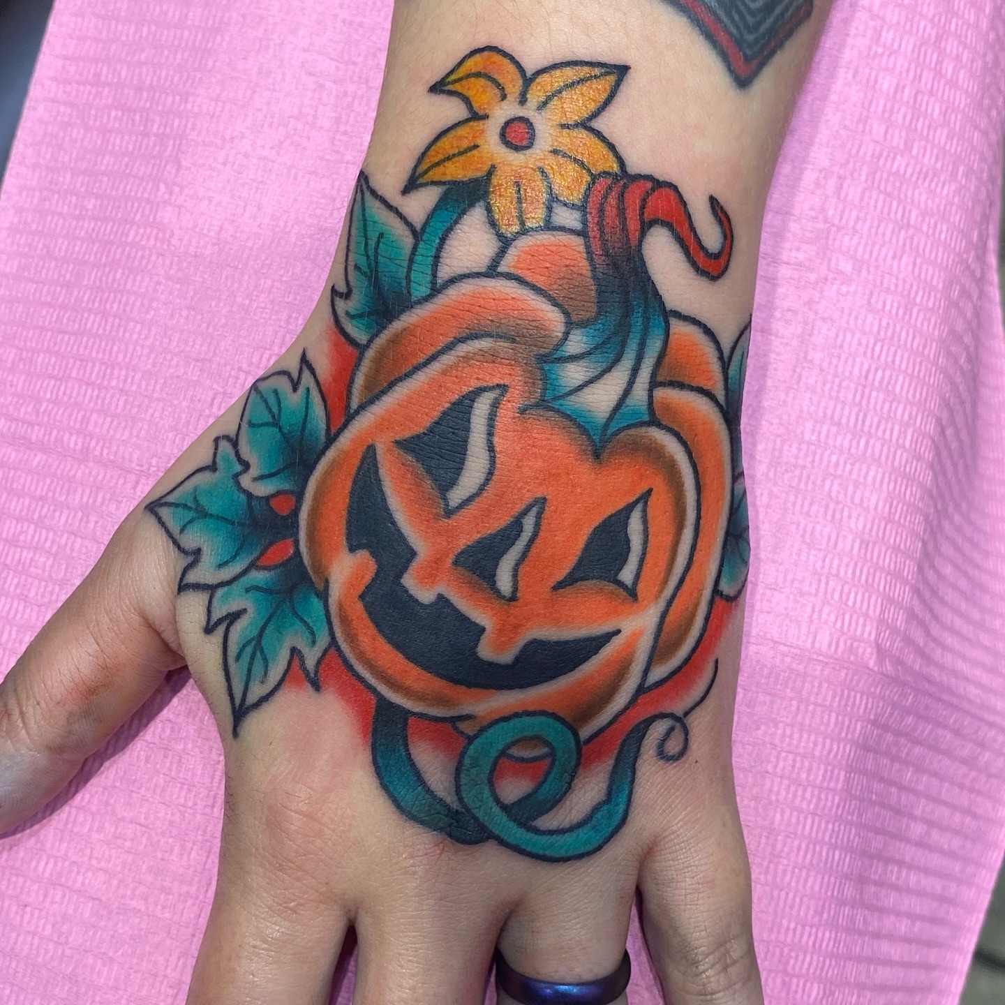 Pumpkin jack-o'-lantern American traditional tattoo on the hand by @katie_tatts