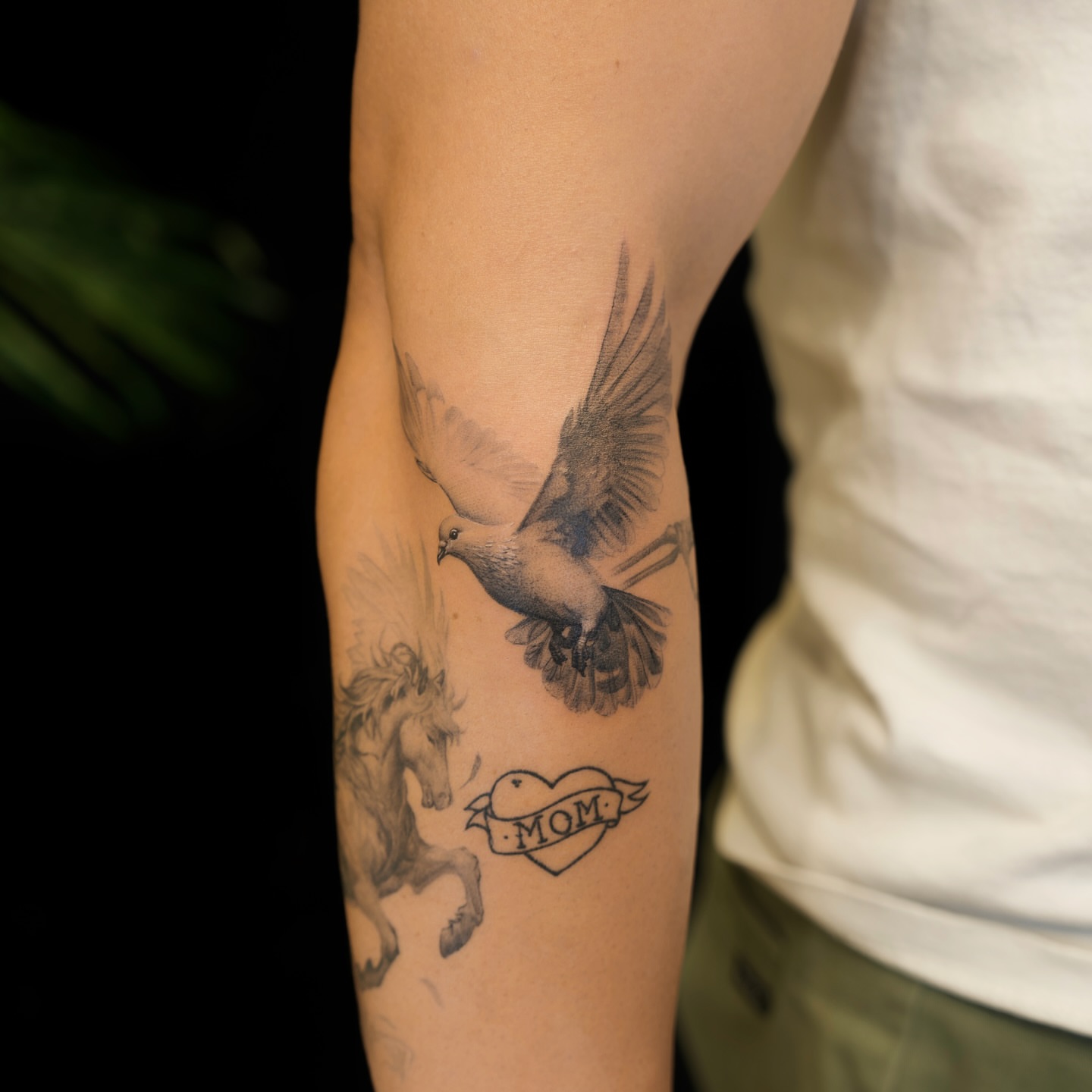 Dove and horse black and grey tattoo on the forearm by Gen Li