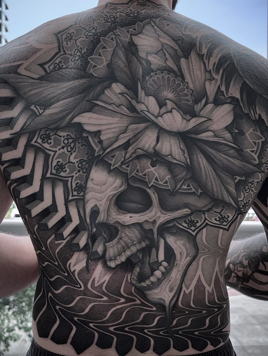 Skull and flowers realism tattoo on the back by Jymi Calkins
