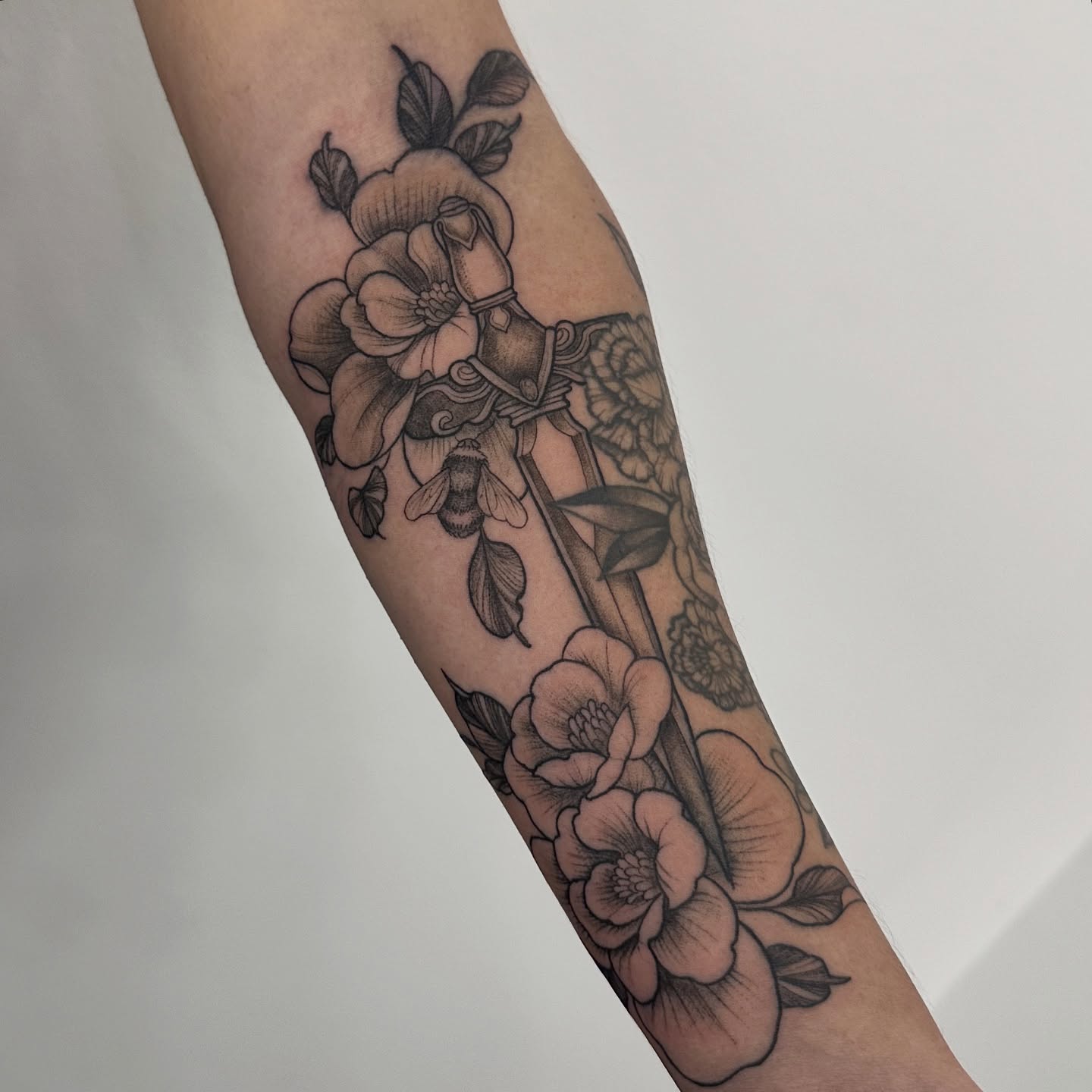 Floral arrangement black and grey tattoo on the forearm by ๐ฌ๐๐๐ฏ๐ ๐ฆ ๐๐ฉ๐ฆ๐ท๐๐๐ข๐ฑ๐ฅ ๐ซง๐ผ, Joplin, Missouri