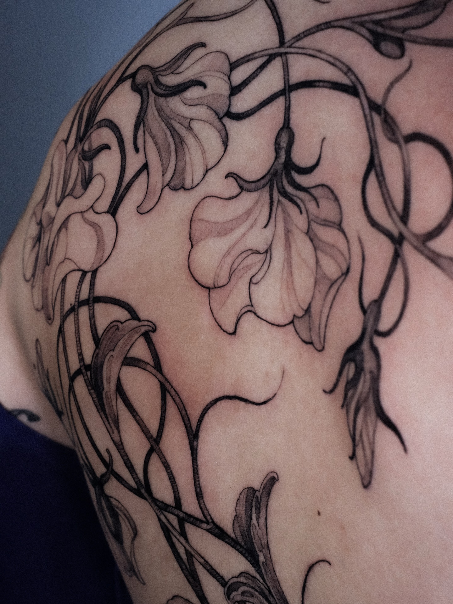 Floral vine black and grey tattoo on the shoulder by Alena Zozulenko