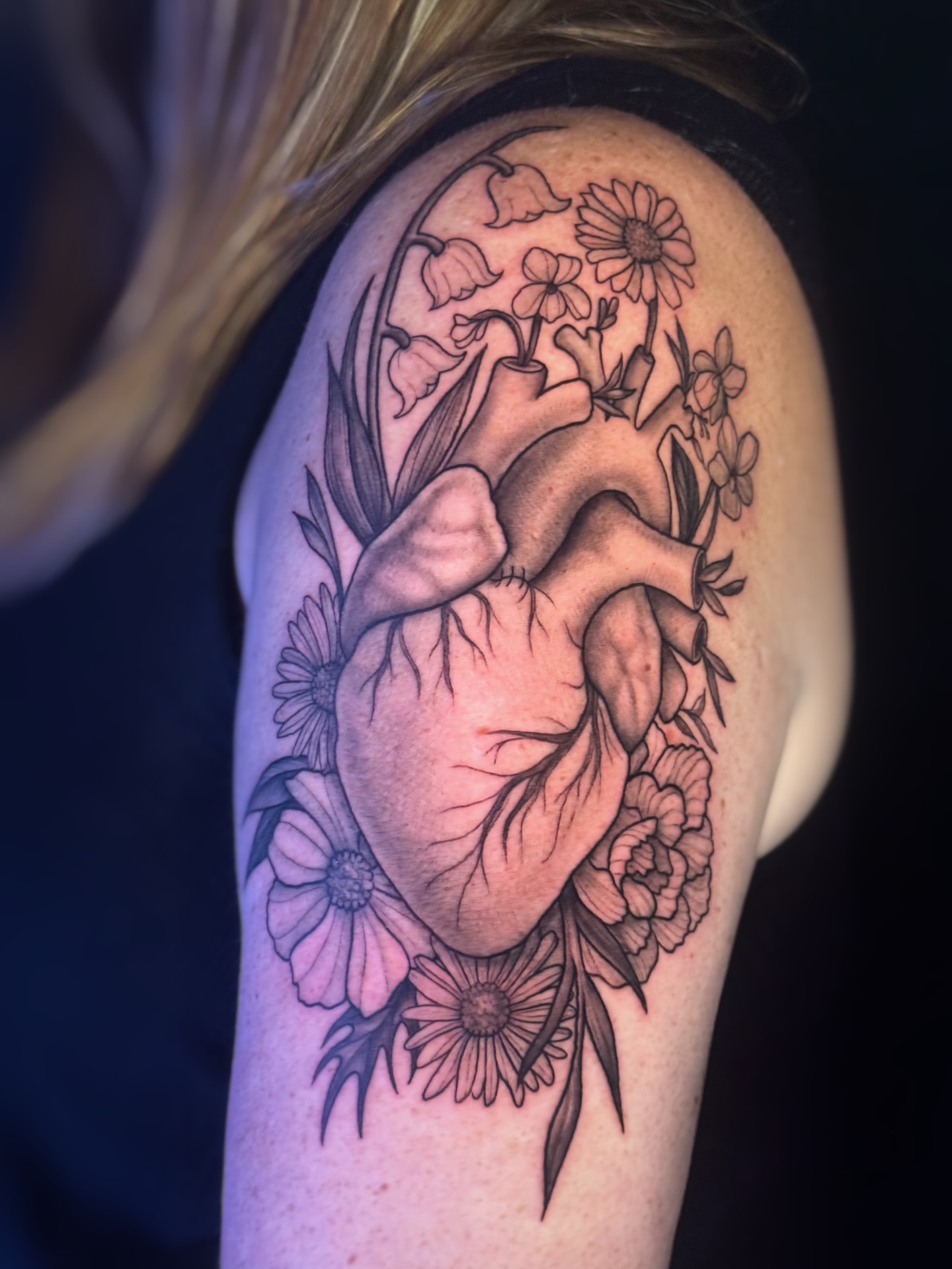 Heart with flowers black and grey tattoo on the shoulder by Lily Bejarno