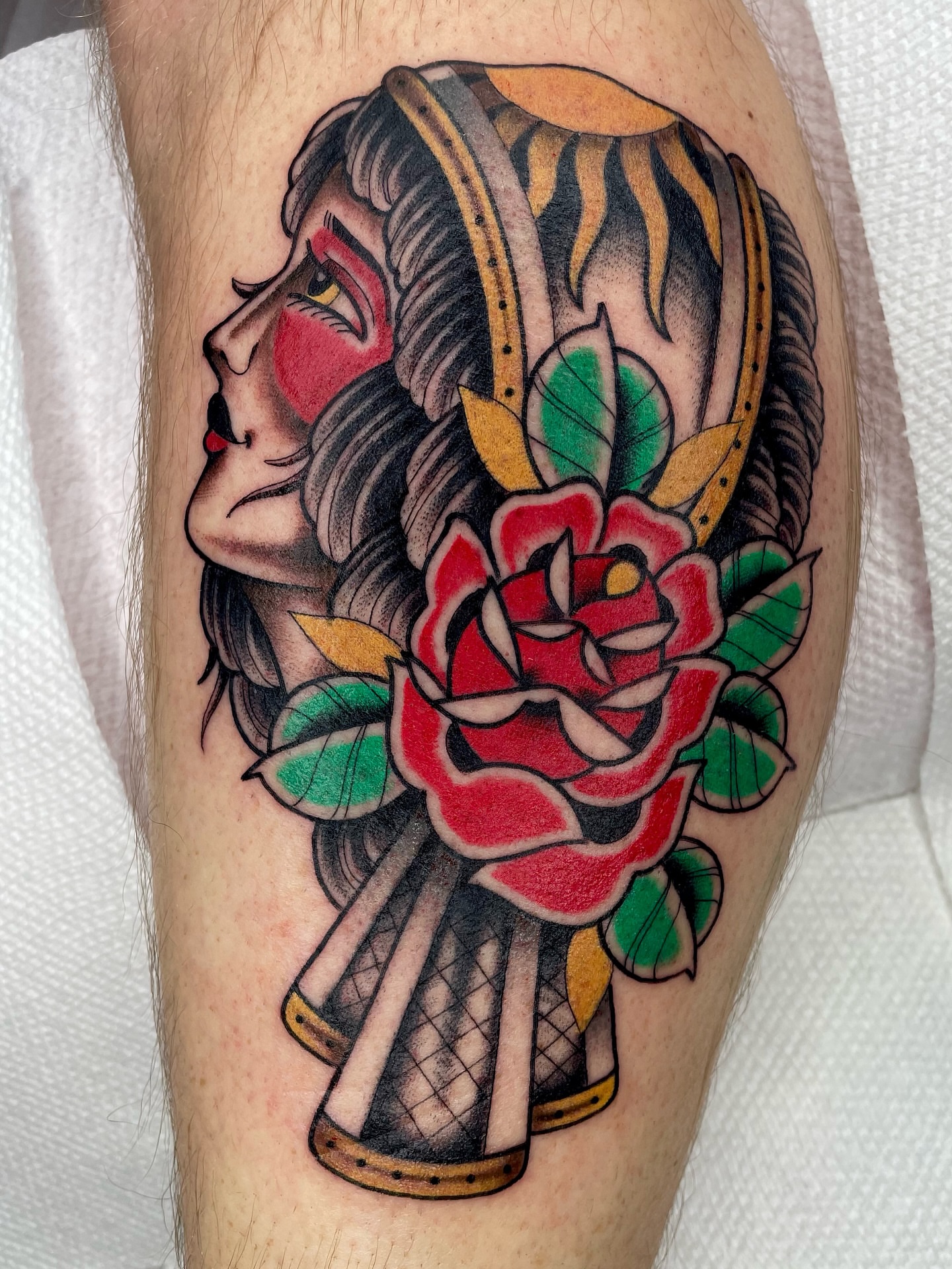 Woman with rose American traditional tattoo on the forearm by Josh Johns