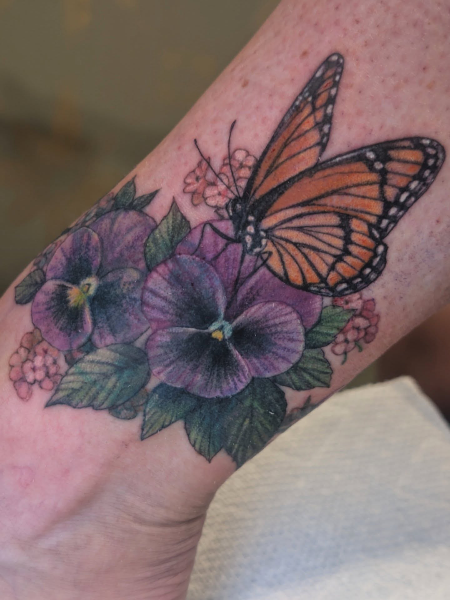 Monarch butterfly and pansies realism tattoo on the forearm by 💎 Neon