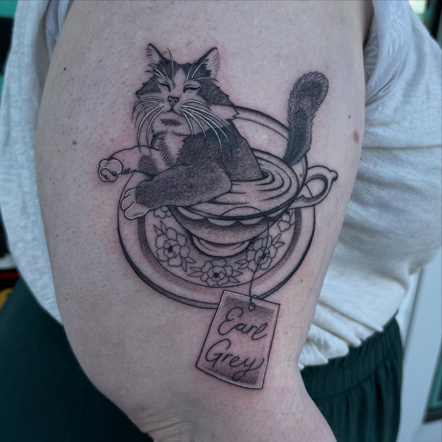 Cat in teacup realism tattoo on the upper arm by Sierra Hiddleson- Phoenix Arizona Tattoo