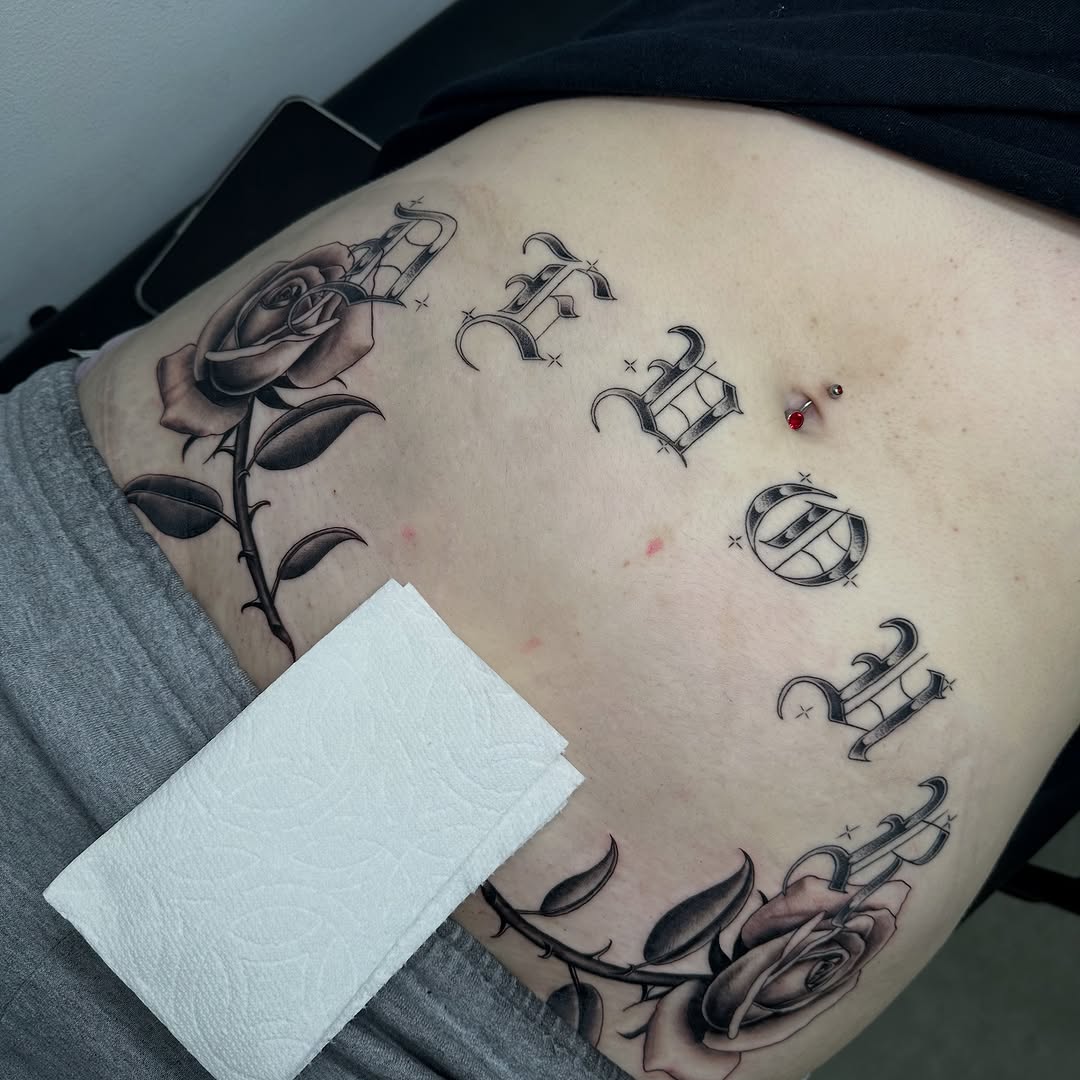 Roses and gothic lettering Chicano tattoo on the ribs by christina diaz