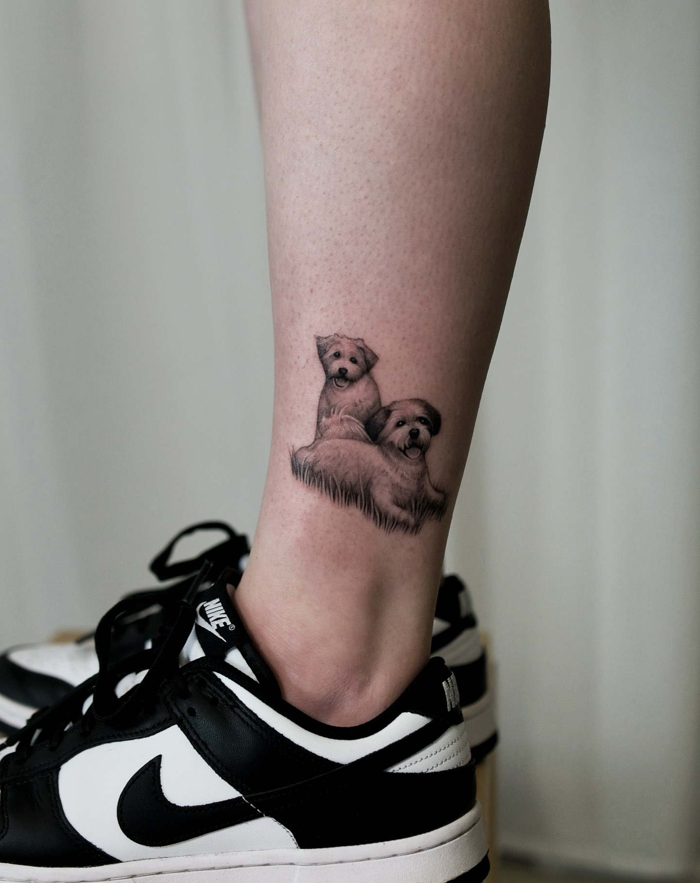 Two dogs realism tattoo on the calf by Ray Quinday