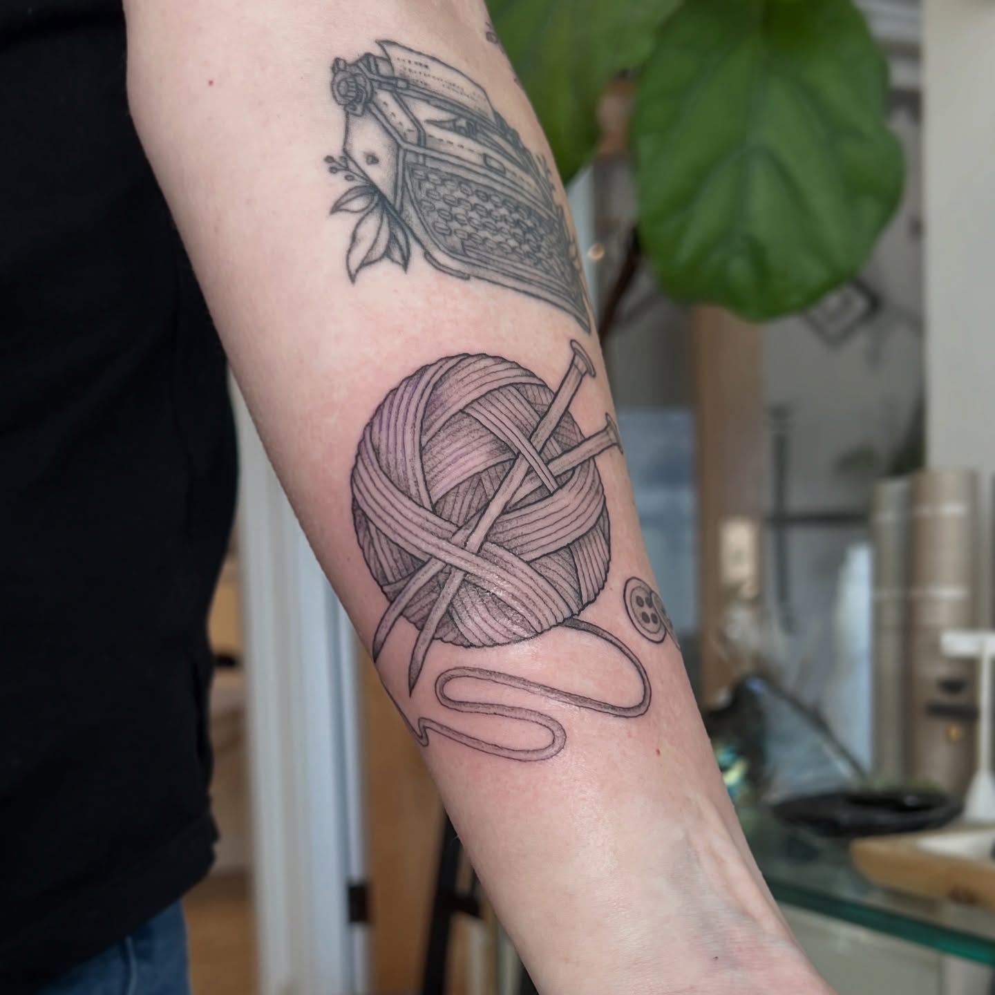 Yarn ball and knitting needles black and grey tattoo on the forearm by Kelsi Hooper, Seattle, Washington