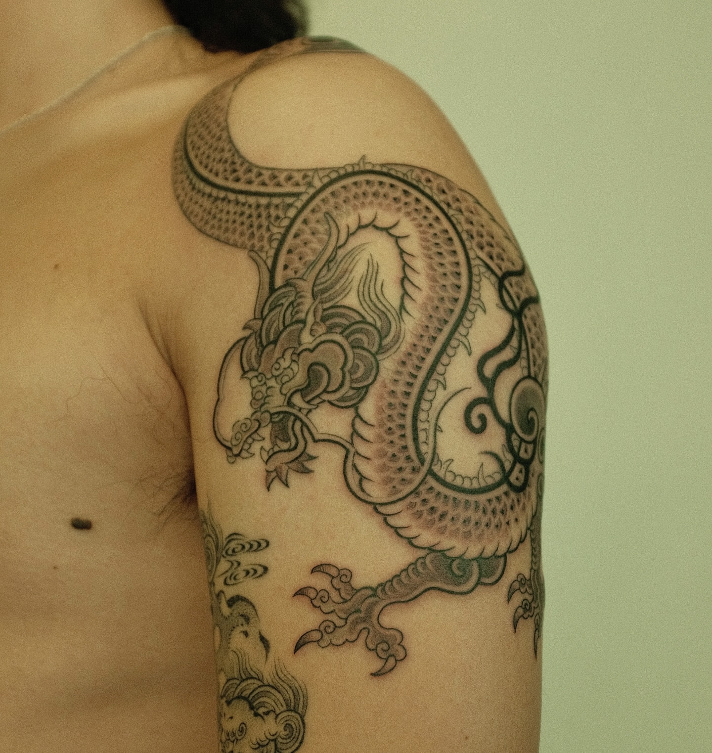 Dragon black and grey tattoo on the shoulder by Xiao Lun