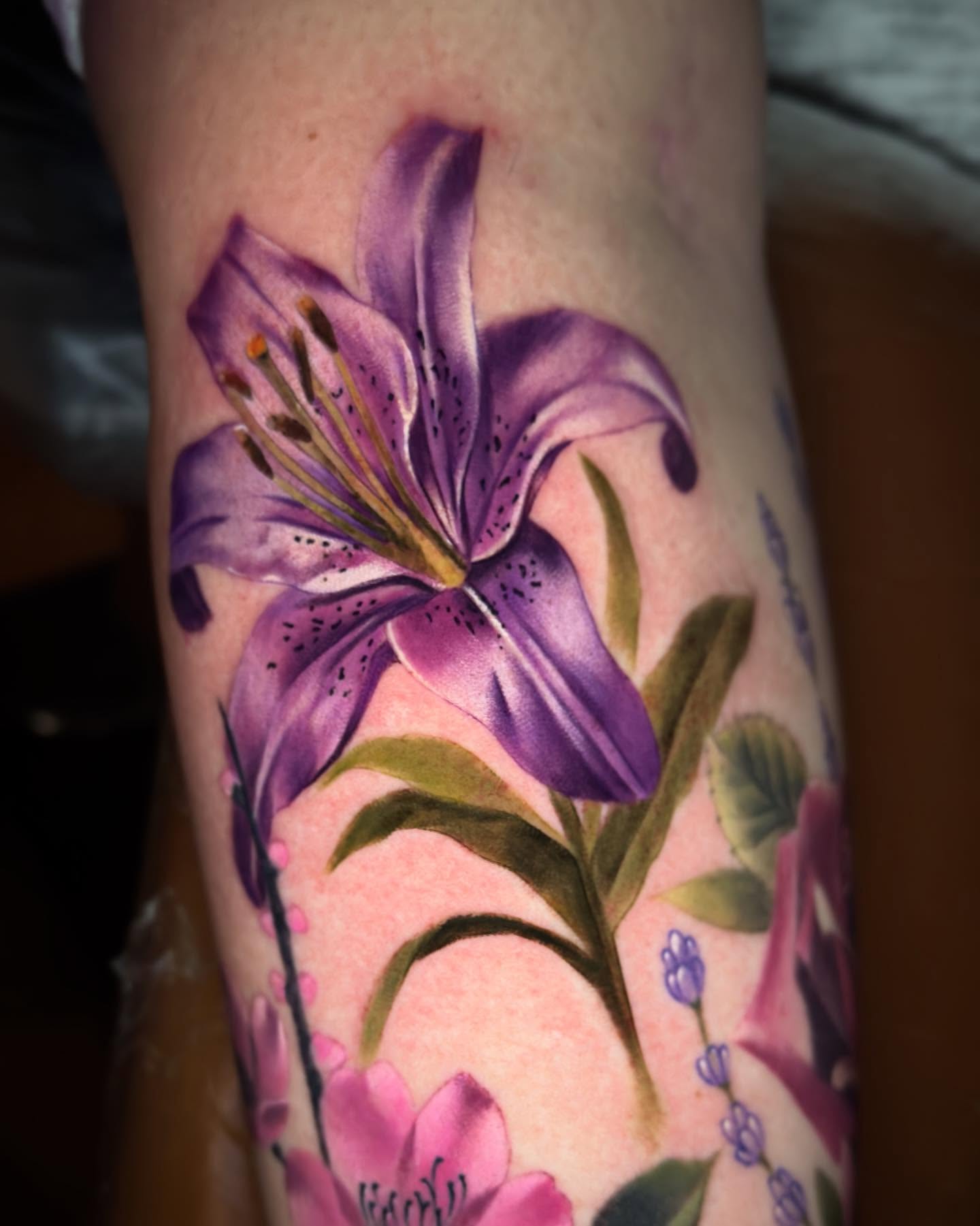 Purple lily realism tattoo on the forearm by Bruce becerra tattoos
